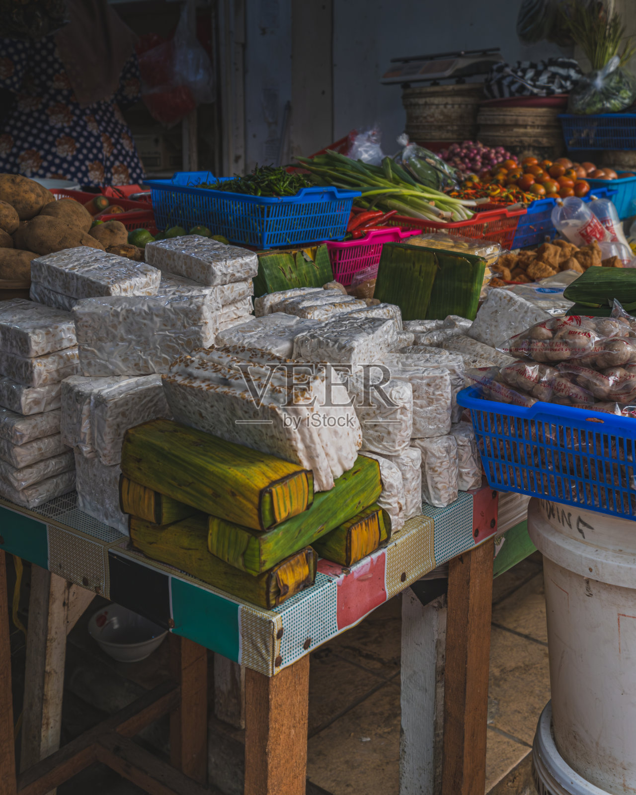 一堆坦佩在市场上的其他一些食品原料和蔬菜中可以买到。照片摄影图片