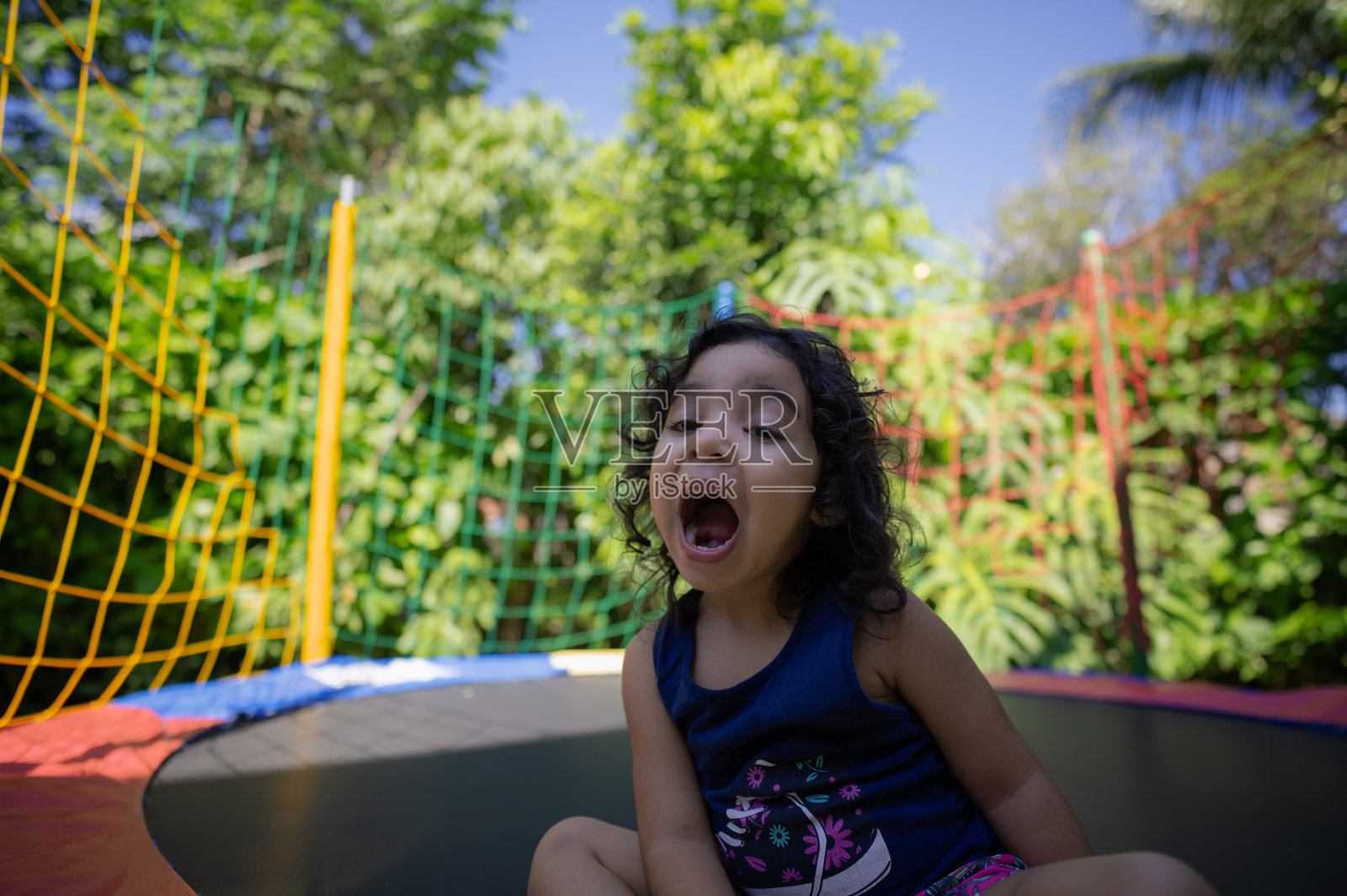 女孩喜欢在蹦床上唱歌跳舞。照片摄影图片