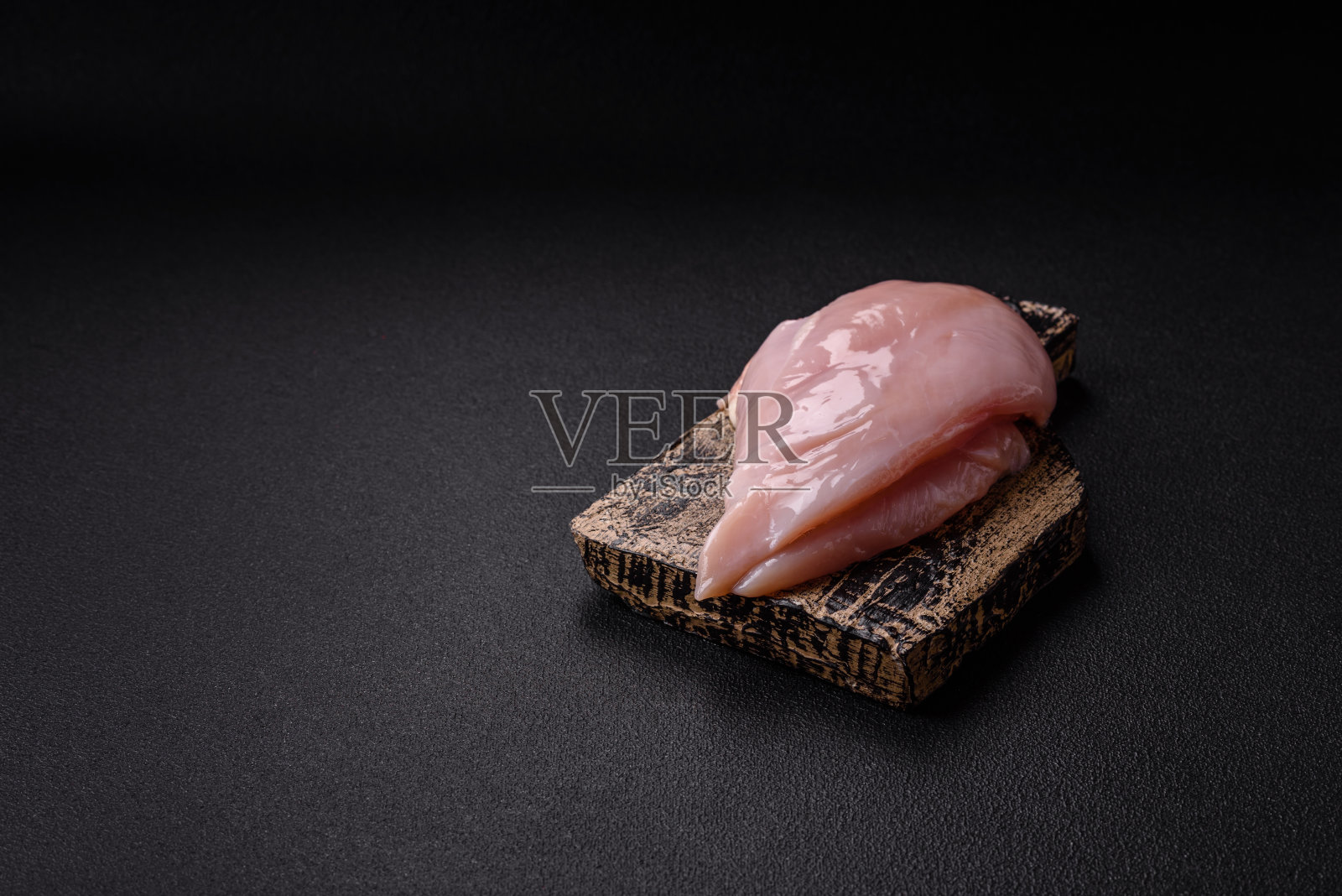 新鲜的鸡肉片放在深色的混凝土桌子上，配上香料和香草照片摄影图片