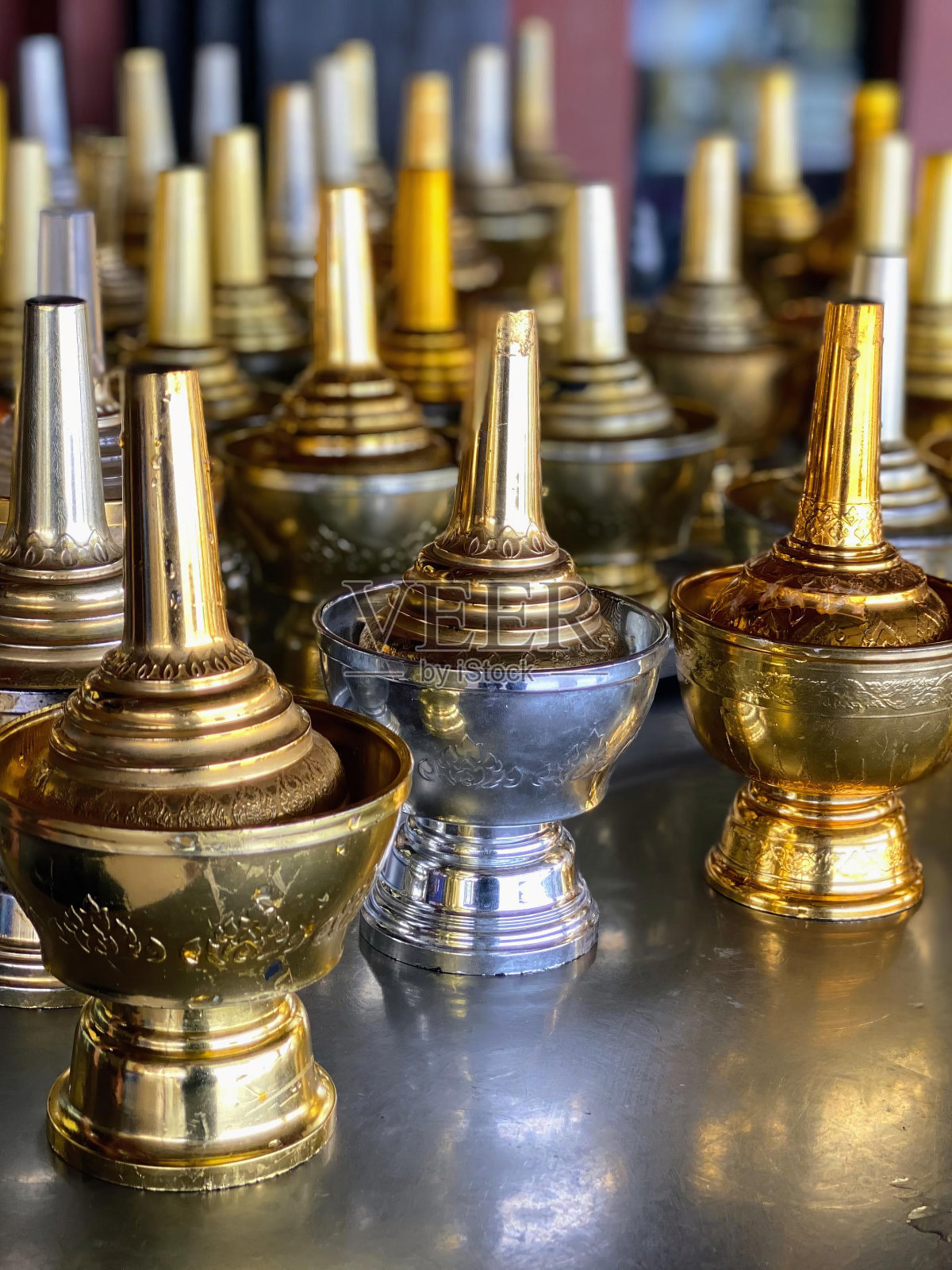 一张桌子上一堆金花瓶的照片。照片摄影图片