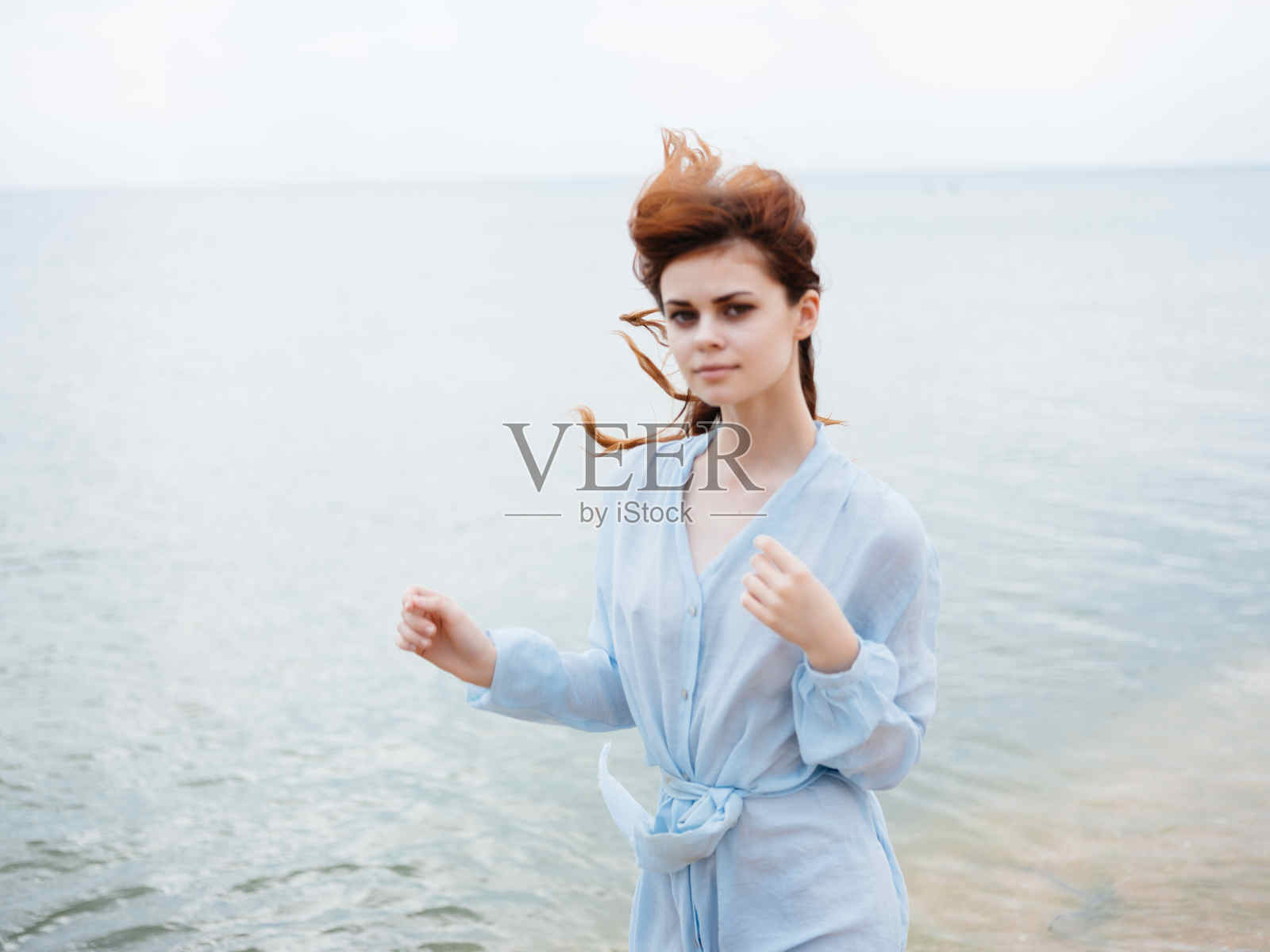 穿着连衣裙的红发女子在沙滩上自由漫步风景照片摄影图片