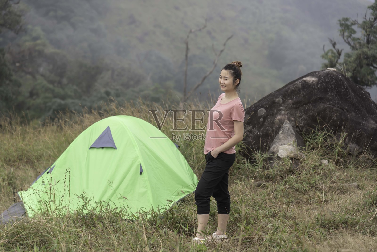 一个女人在山上露营。照片摄影图片