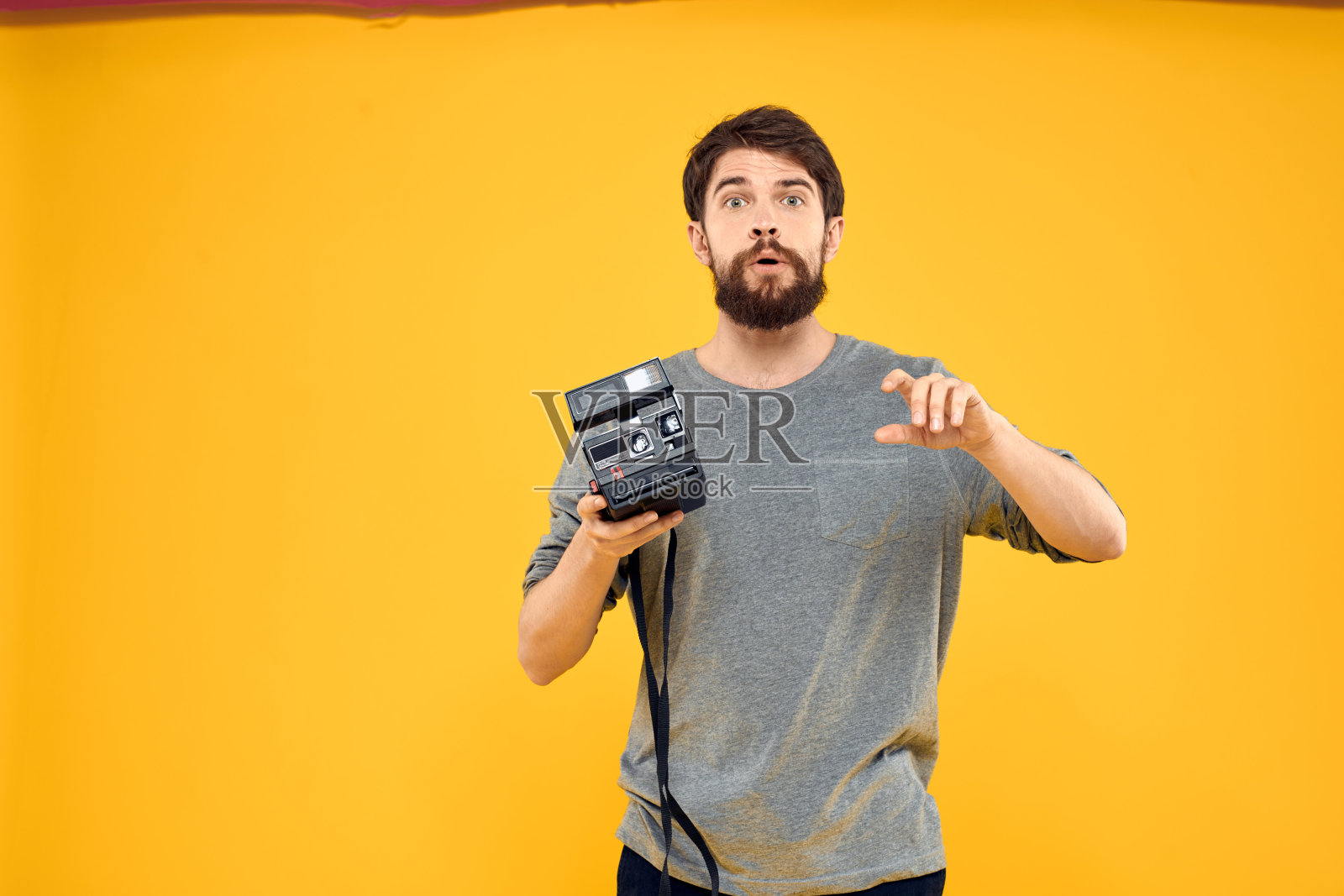 男摄影师，带专业相机。专业创意方法工作室黄色背景照片摄影图片