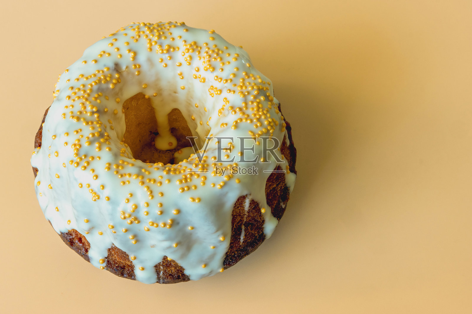 橙色背景上装饰着白色糖霜的棕色纸杯蛋糕照片摄影图片