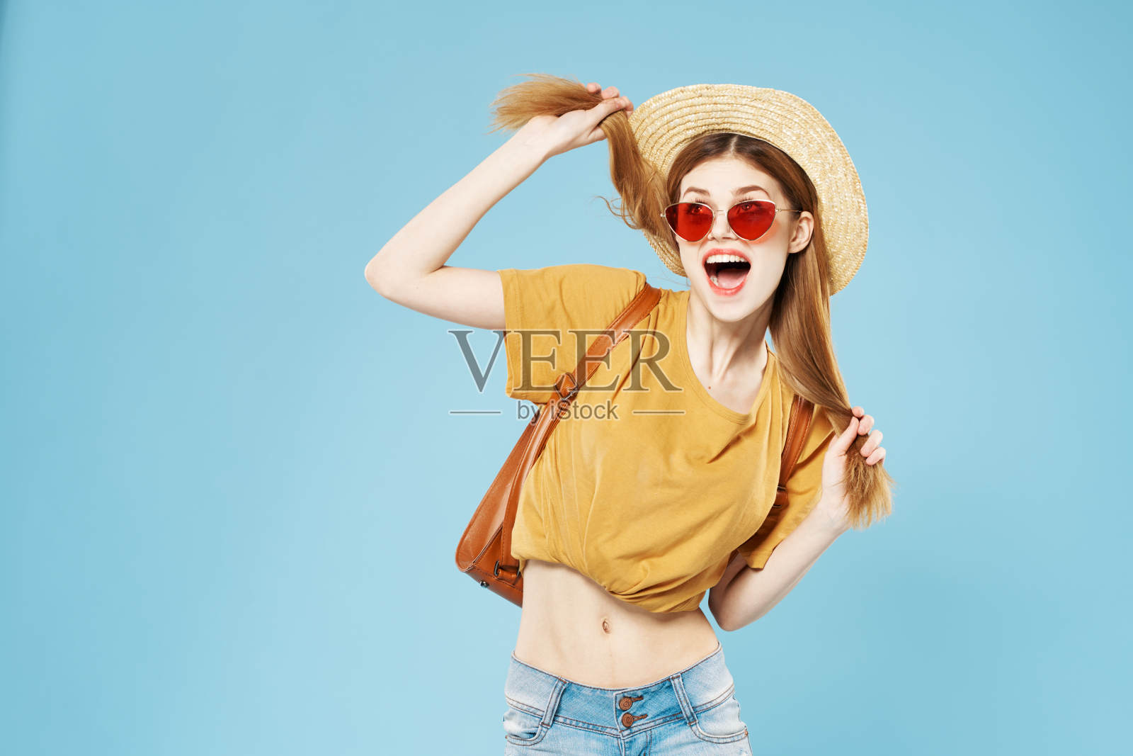 开朗漂亮的女人戴着帽子和太阳镜，头发背包，情感生活方式照片摄影图片