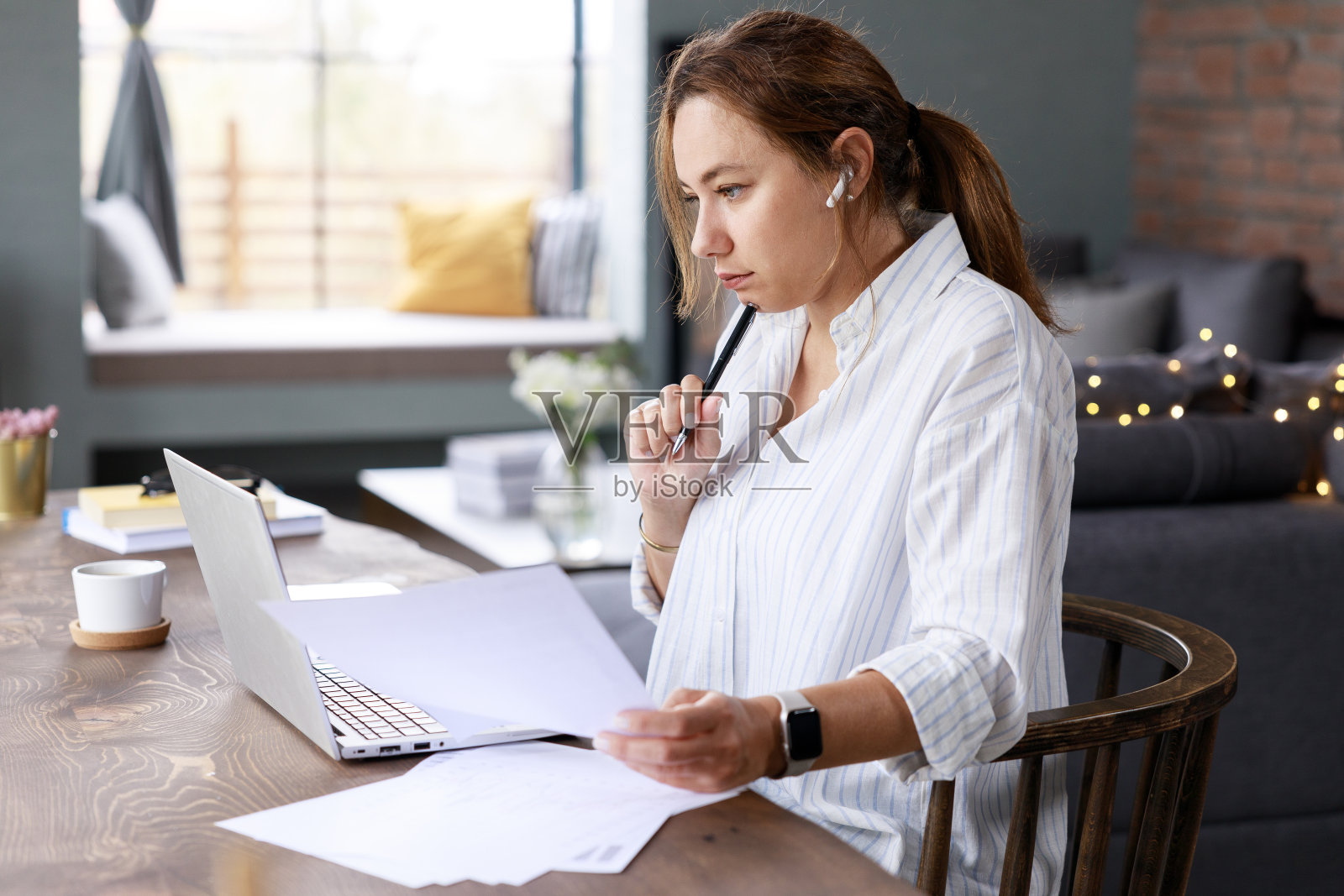 年轻的自由职业女商人在家用笔记本电脑处理文件照片摄影图片