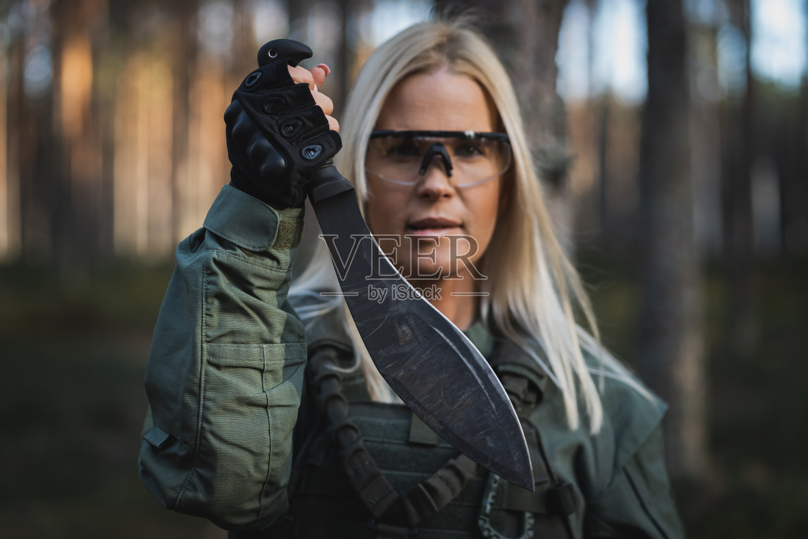 一个士兵女孩手里拿着一把大的库克里刀，柔焦照片。照片摄影图片