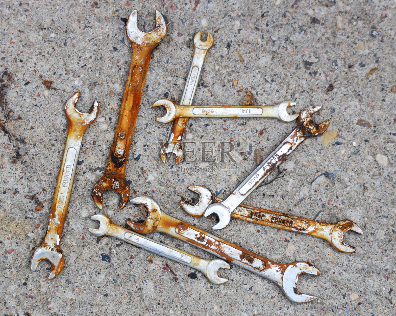 水泥背景下生锈的扳手的俯视图。机械修理工具。照片摄影图片