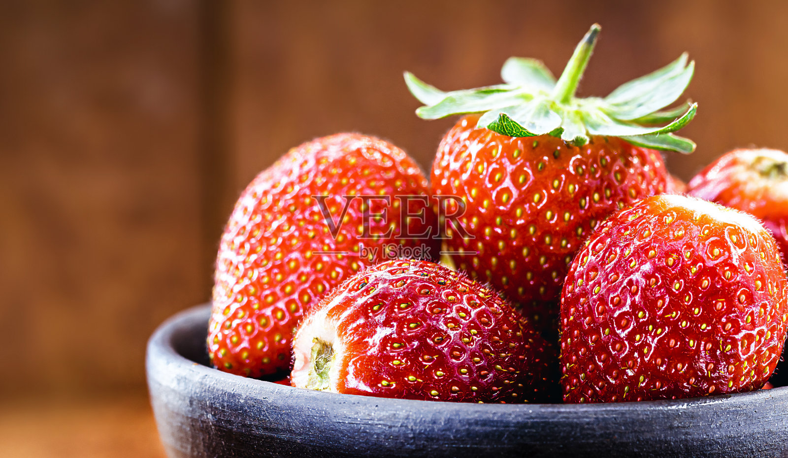 手工陶罐与巴西草莓品种的阿尔比恩，木制背景，copyspace照片摄影图片