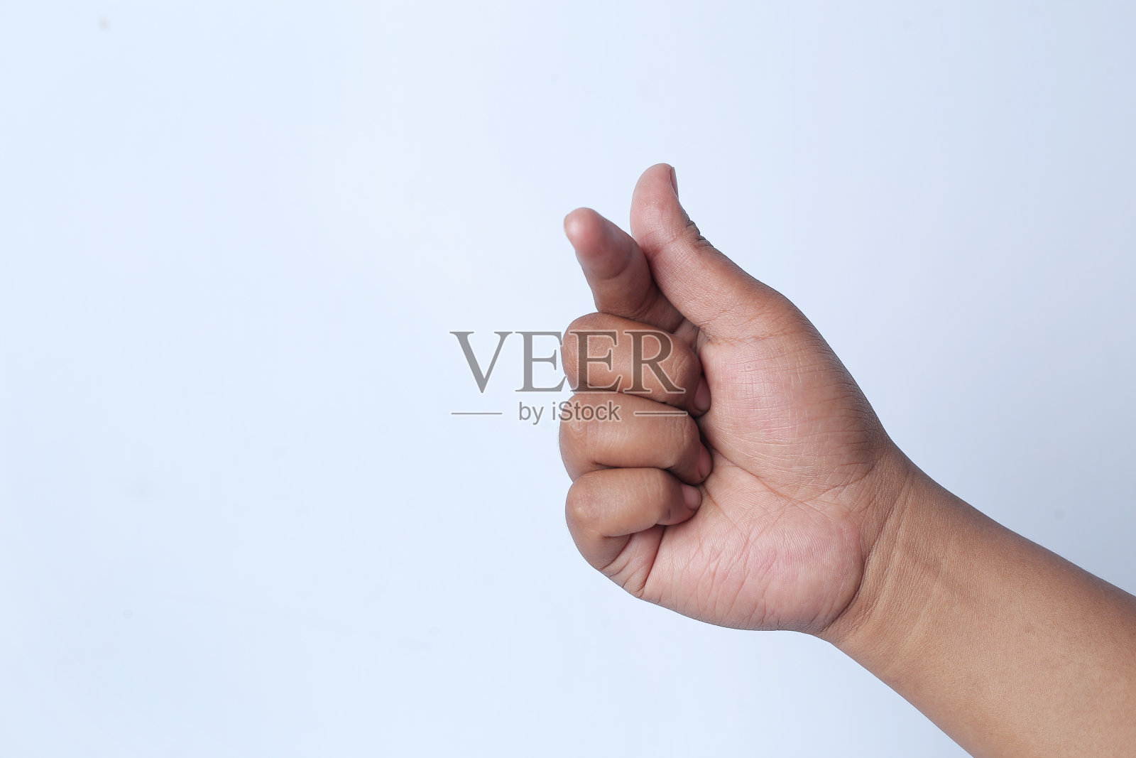 韩国人用手指表示爱。男性的手描绘了一颗心。照片摄影图片