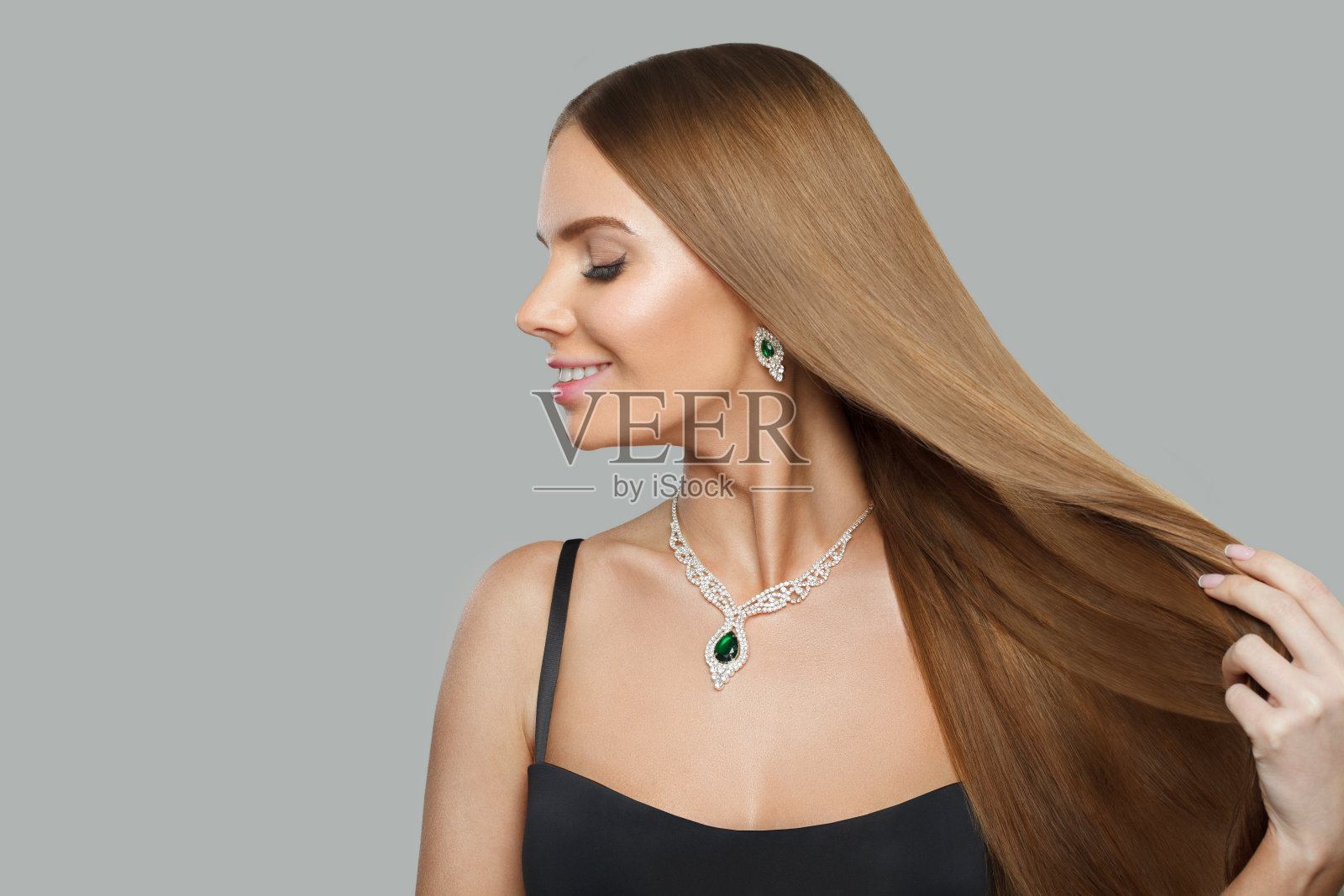 好看的珠宝模特美女肖像。深色头发，头发光滑，戴项链照片摄影图片