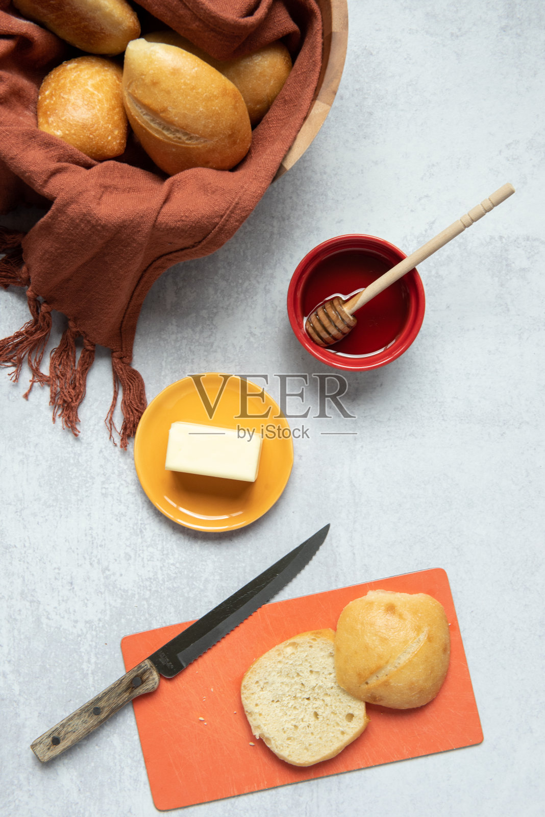 平铺一篮子新鲜的面包卷，涂上黄油和蜂蜜照片摄影图片