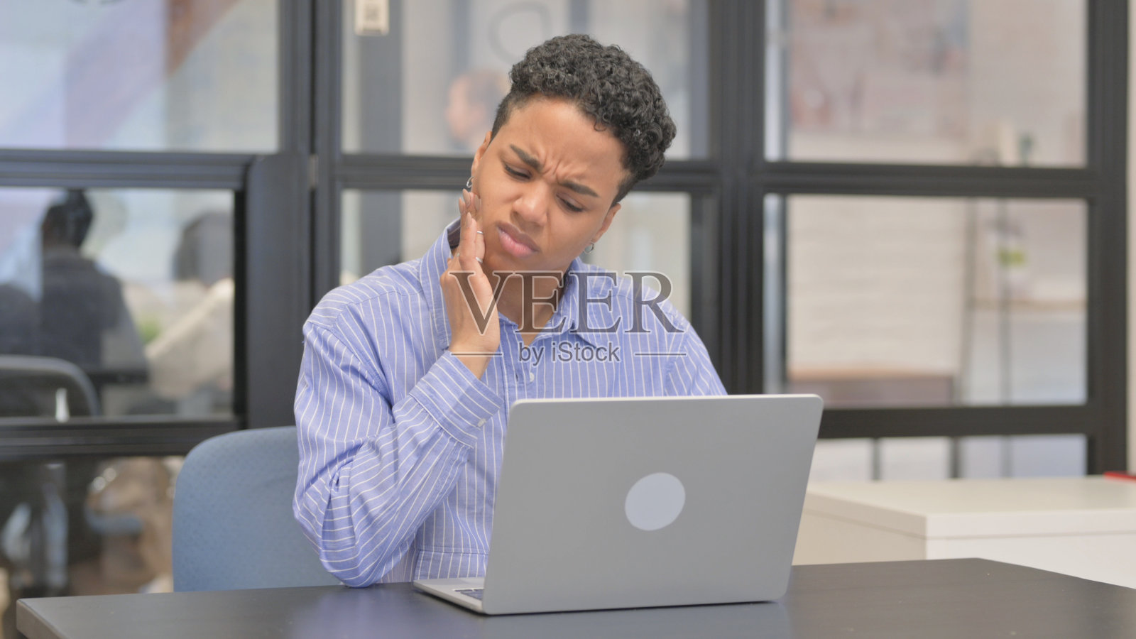 混血女性在使用笔记本电脑时牙痛照片摄影图片