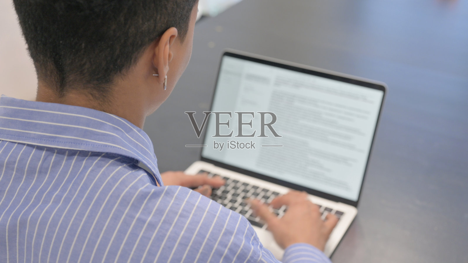 非洲妇女在笔记本电脑上打字的后视图照片摄影图片