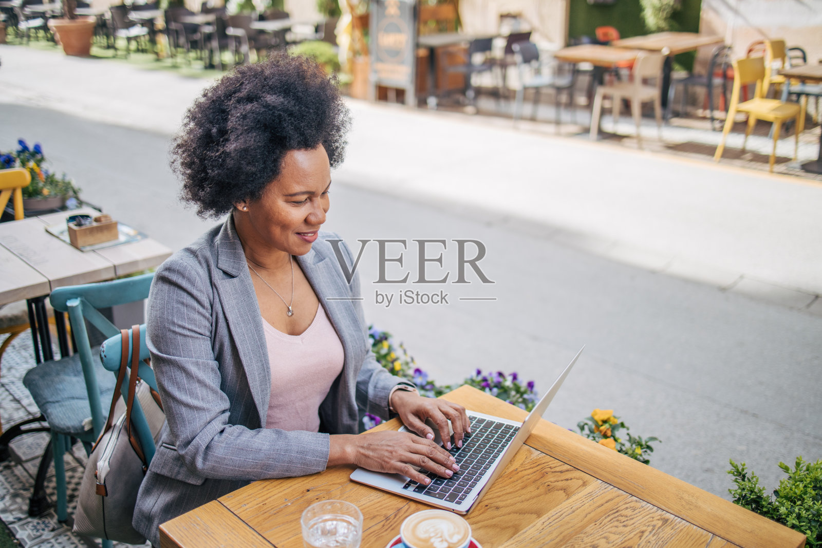黑人女性在咖啡馆户外使用笔记本电脑照片摄影图片