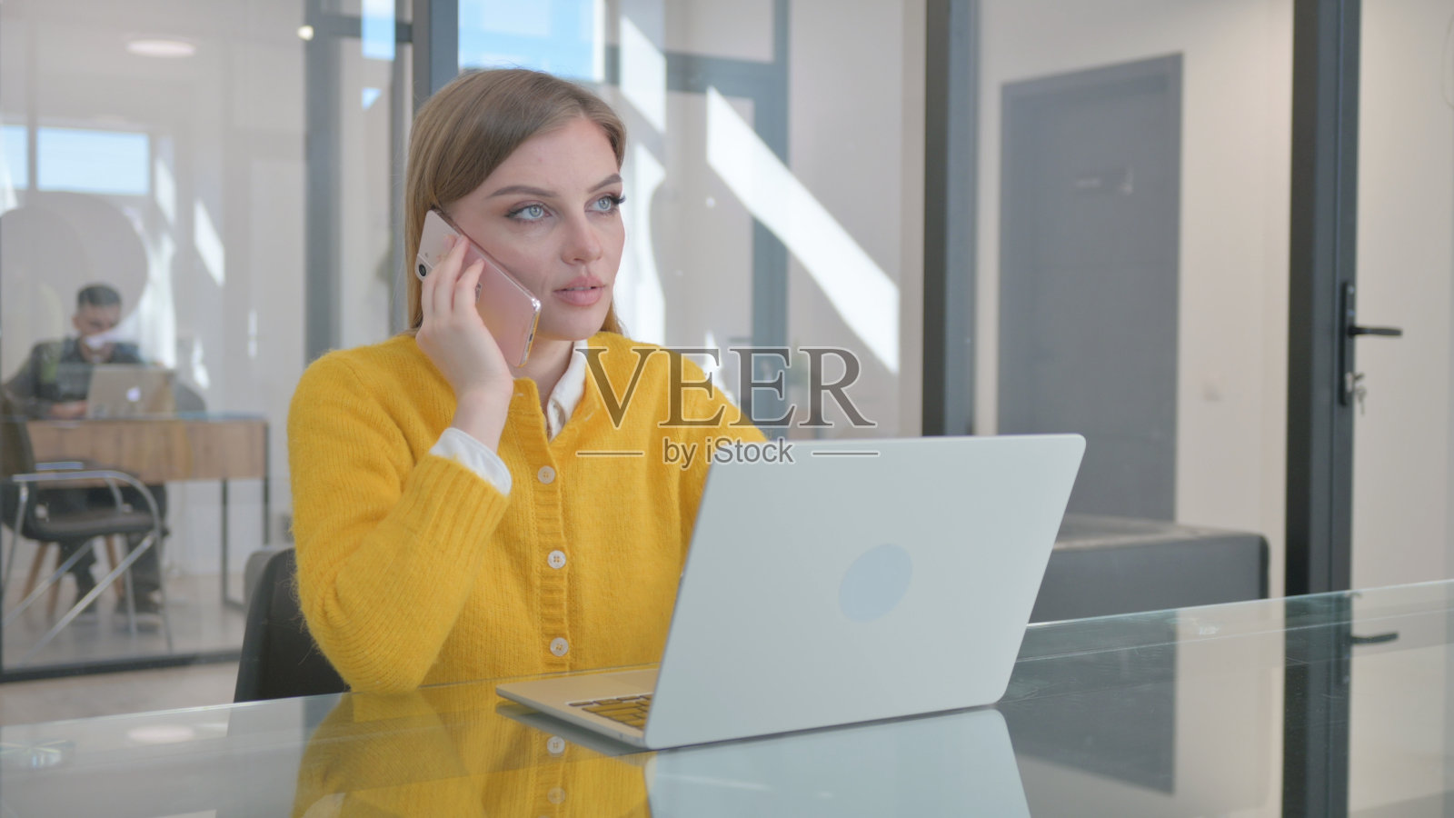 年轻女子在工作时打电话照片摄影图片