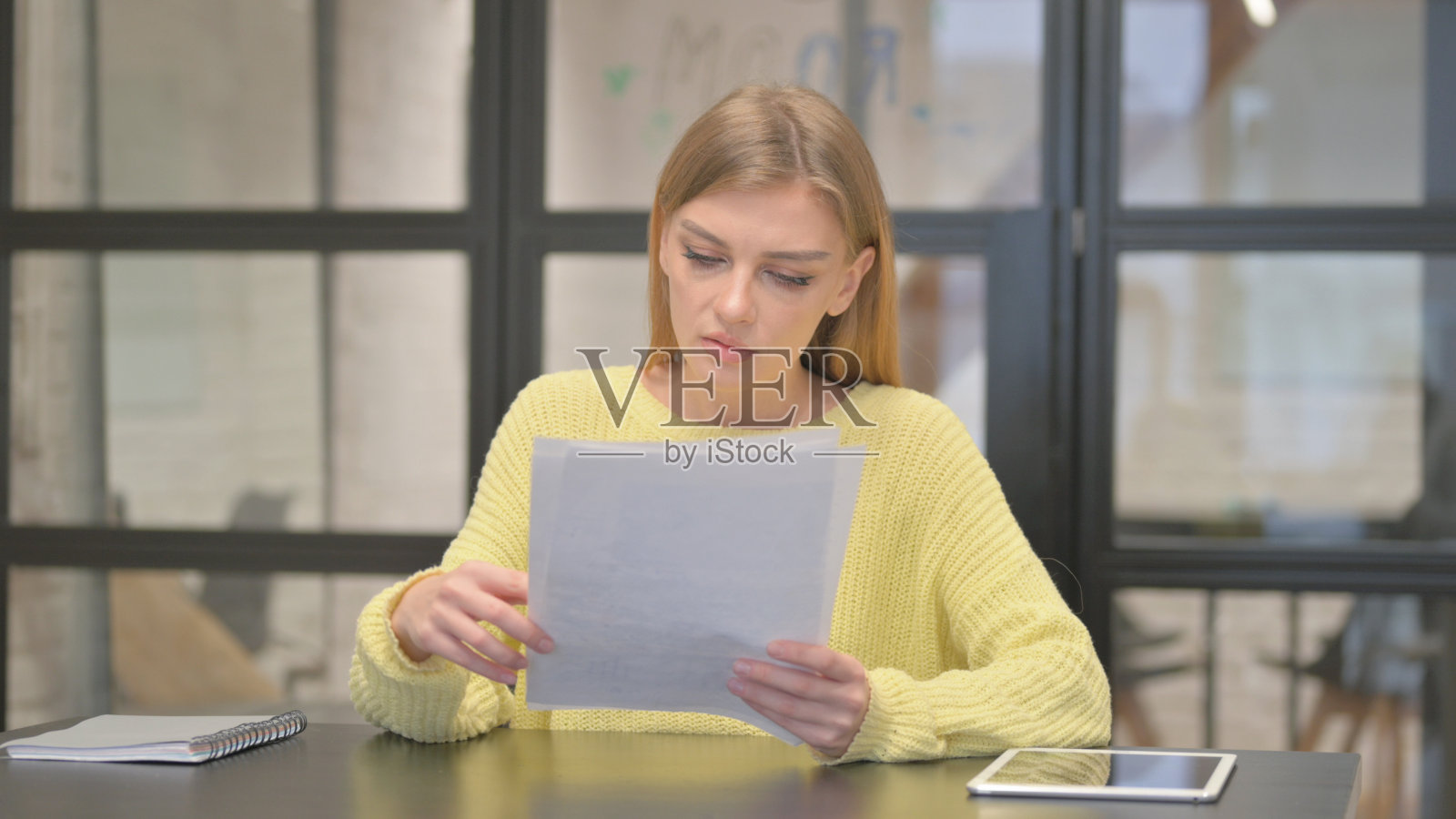 休闲创意女性在工作中阅读文件照片摄影图片