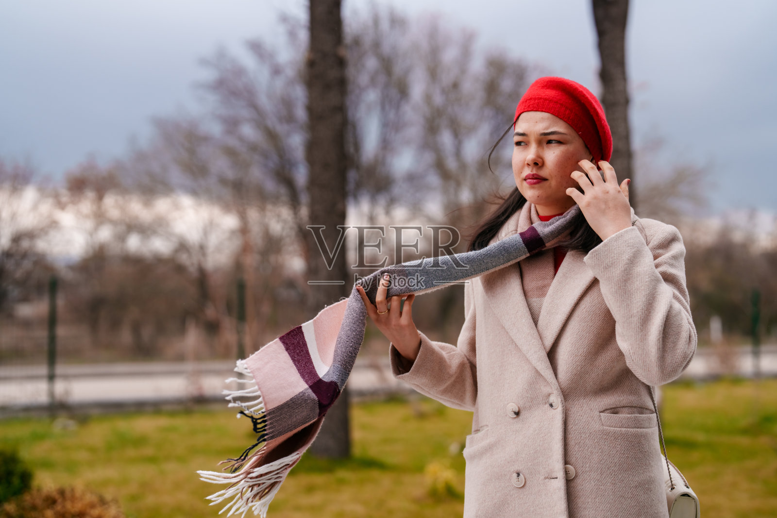 一个戴着红帽子和围巾的亚洲女人的肖像。照片摄影图片