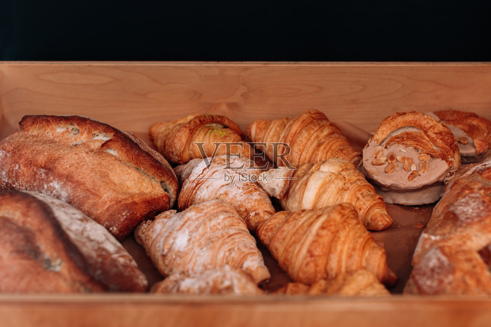 新鲜出炉的法式羊角面包和脆皮面包。柜台上各种各样的烘焙食品照片摄影图片
