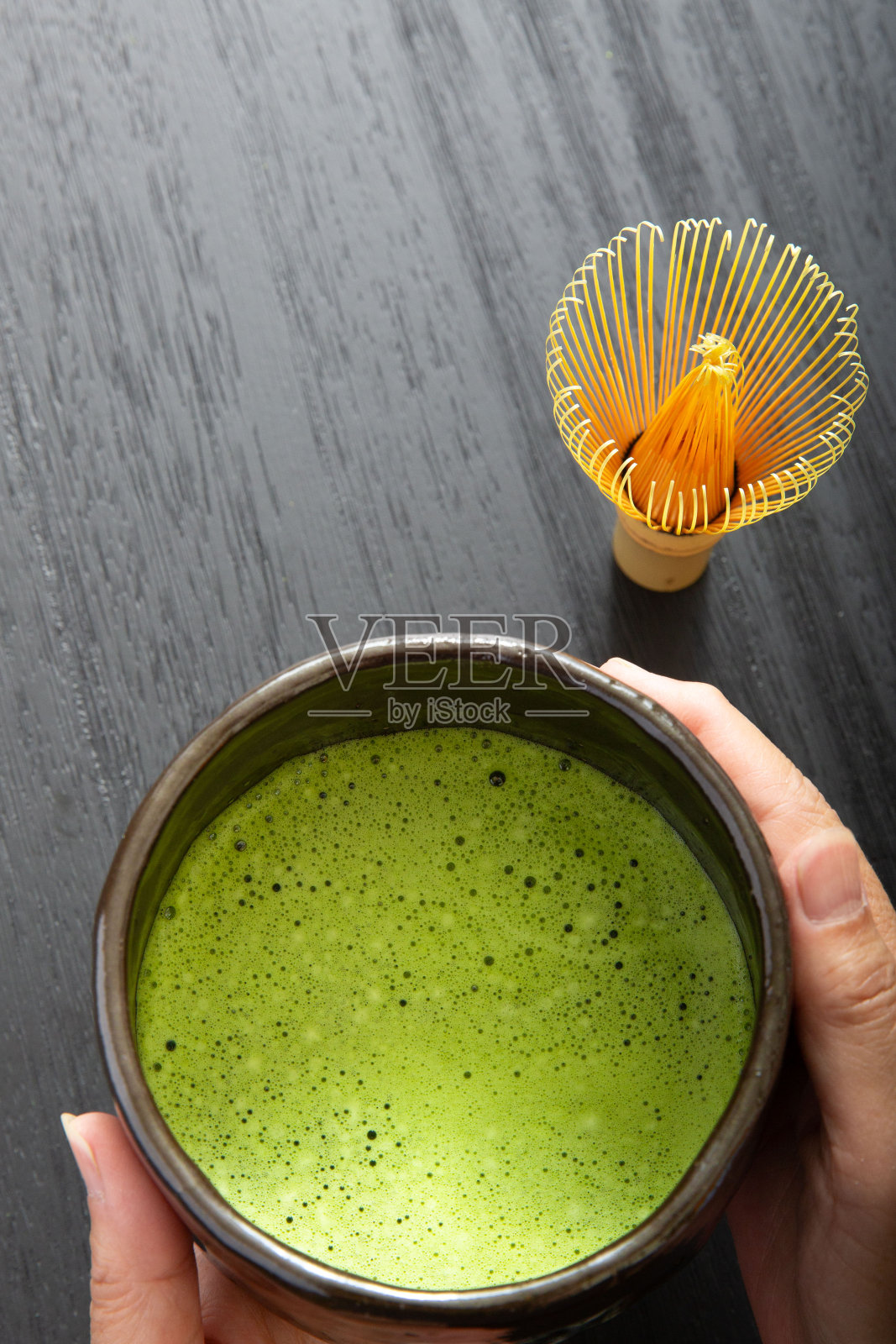 手捧抹茶，黑抹茶碗照片摄影图片