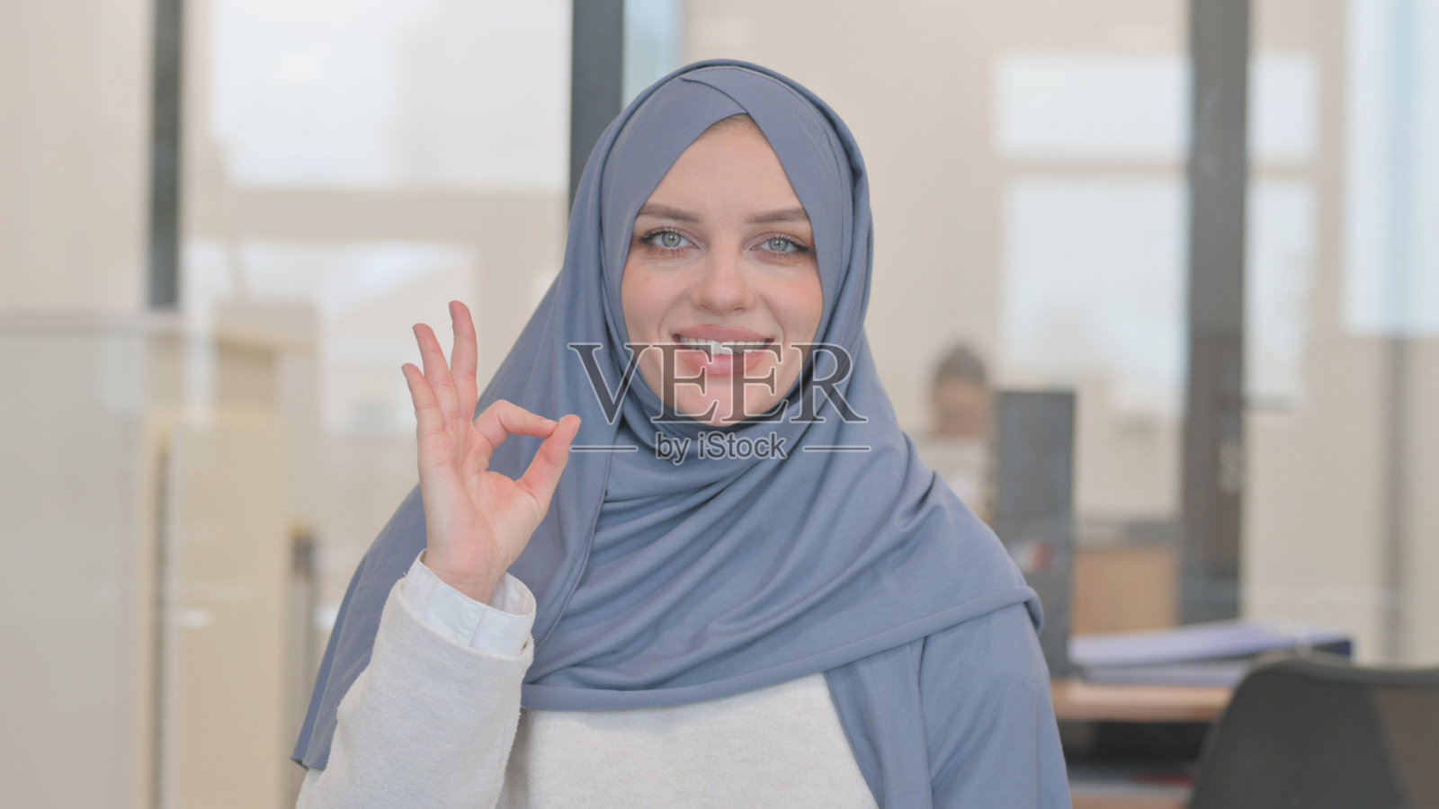 阿拉伯妇女的肖像与ok的标志照片摄影图片