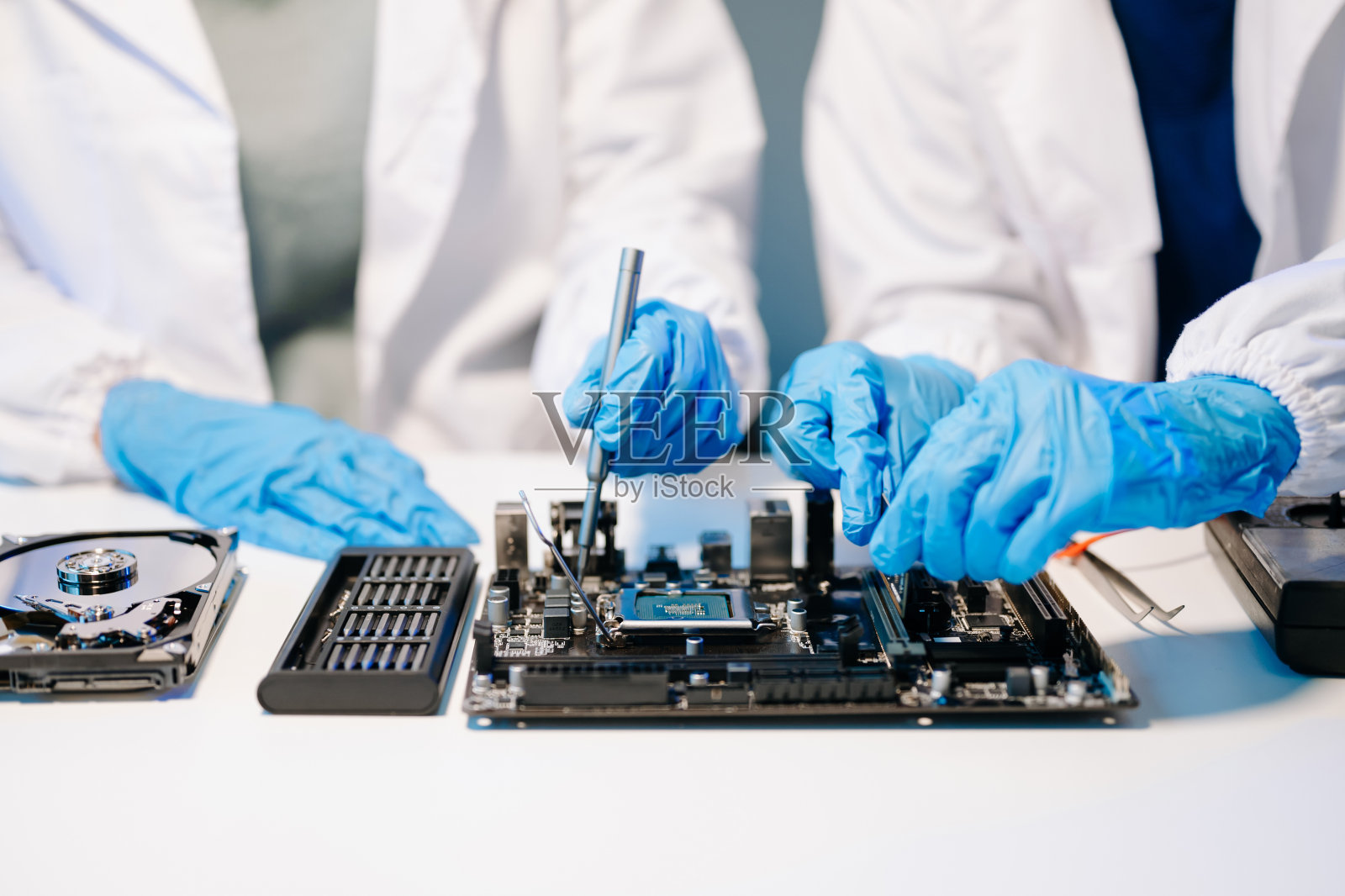 技术人员正在把中央处理器安装到电脑主板的插座上。电子工程、电子维修、电子测量照片摄影图片