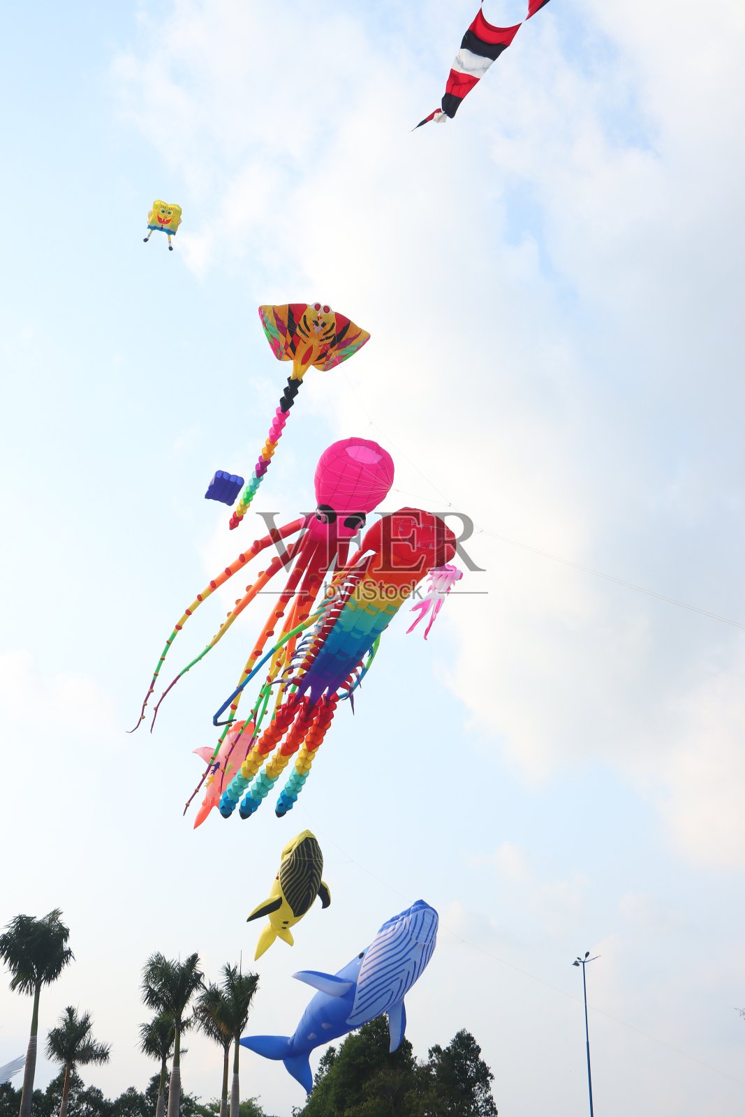 在越南湄公河三角洲阳光明媚的夏日，五颜六色的气球风筝在晴朗的蓝天上飞舞。快乐的童年时光。照片摄影图片