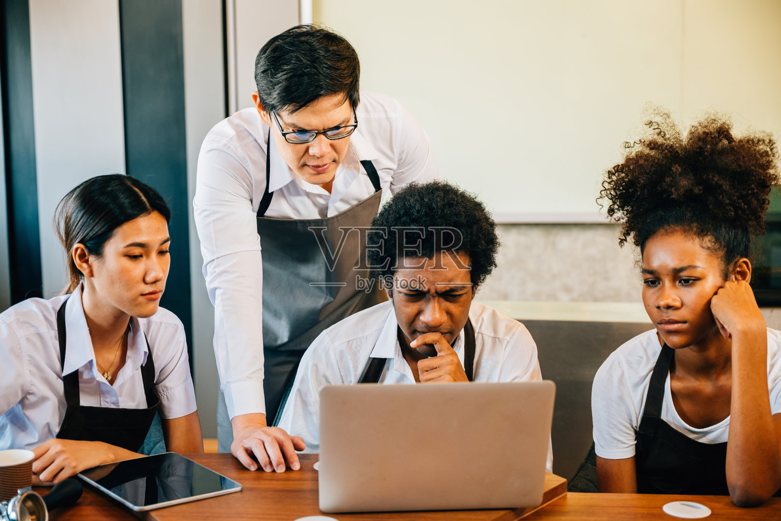 咖啡店经营给年轻创业者带来欢乐、乐趣和自豪。用笔记本电脑规划管理带来满足感。咖啡师老板合作成功团队合作的笑脸。照片摄影图片