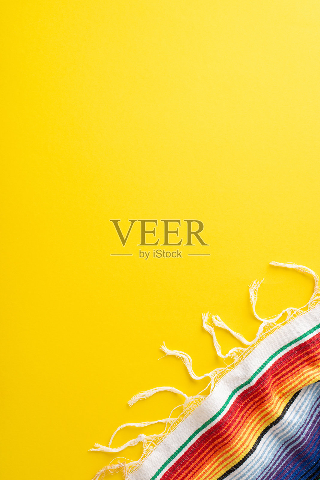 五月五日节活动写照。俯视图垂直照片捕捉聚会必备:明亮的条纹披风在阳光明媚的黄色背景，有空间的说明文字照片摄影图片