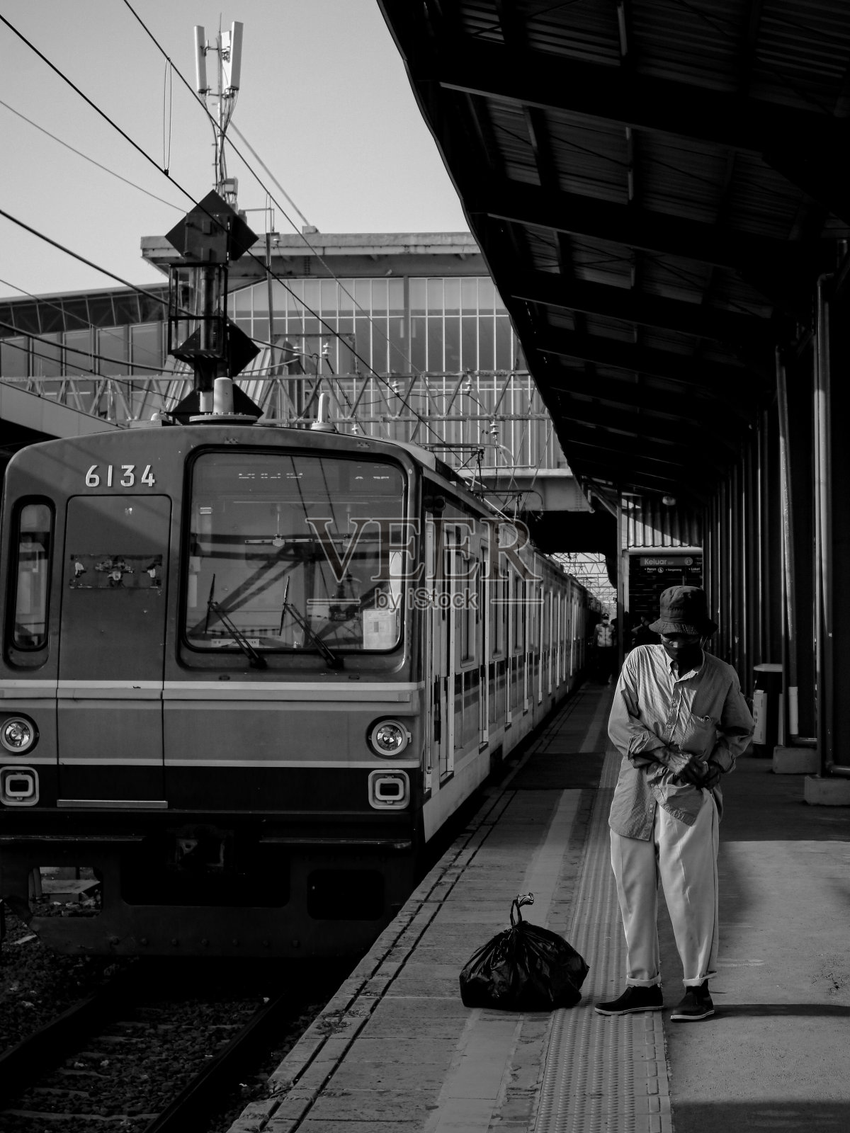 一名男乘客提着一个大塑料袋等着上车照片摄影图片