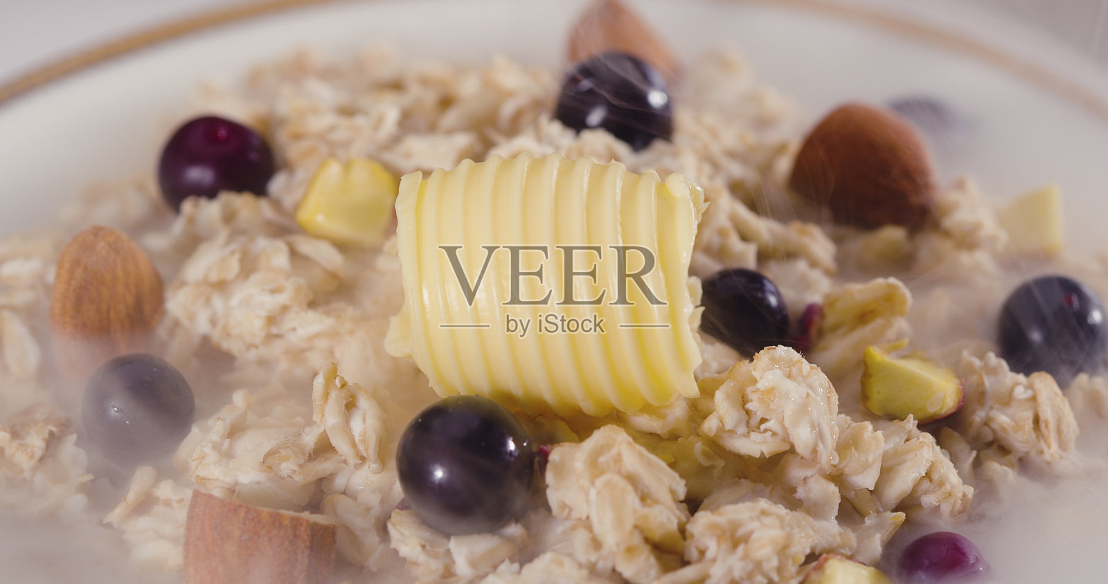 加黄油的热燕麦粥。照片摄影图片