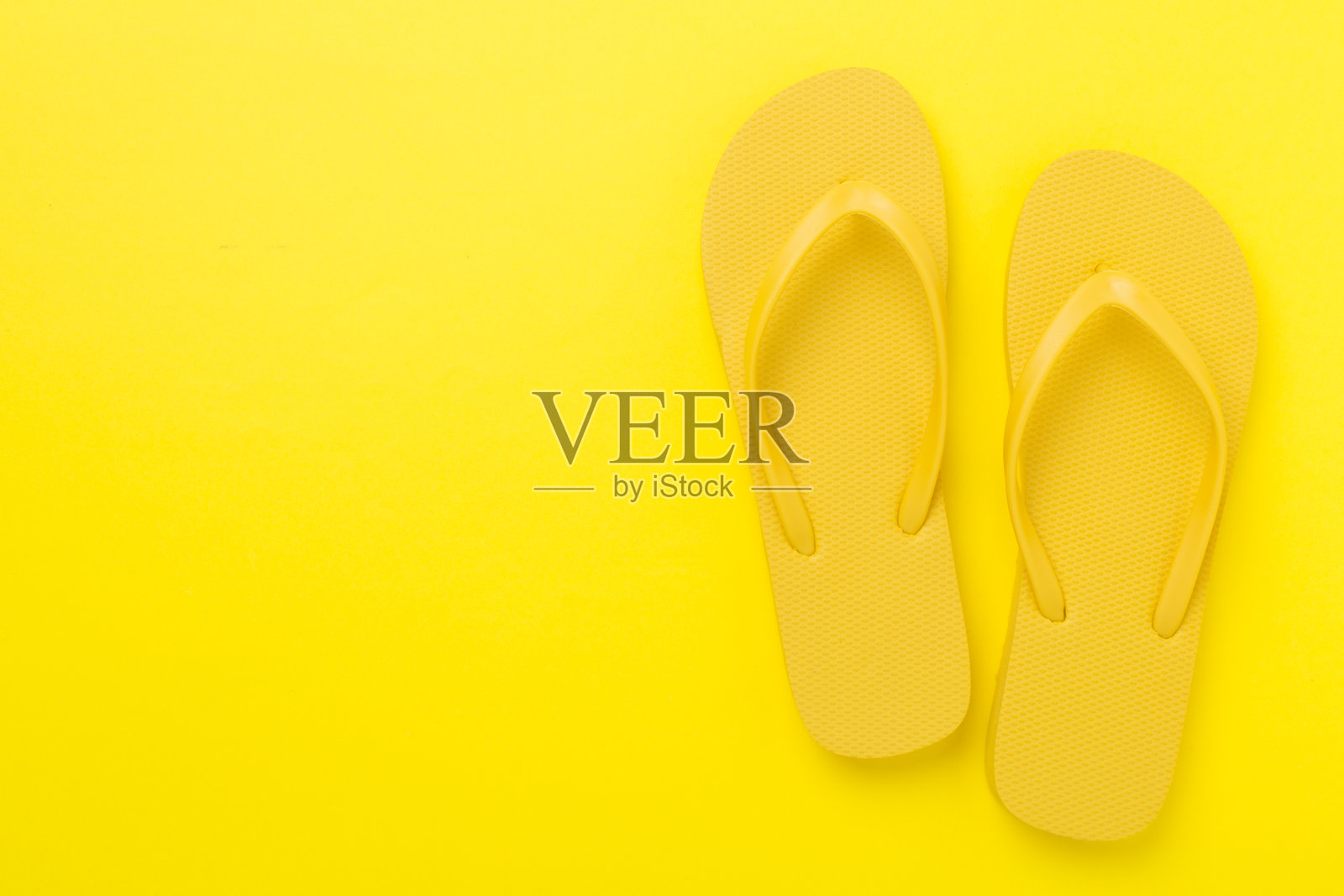 亮黄色人字拖，彩色背景，俯视图。夏天的概念照片摄影图片