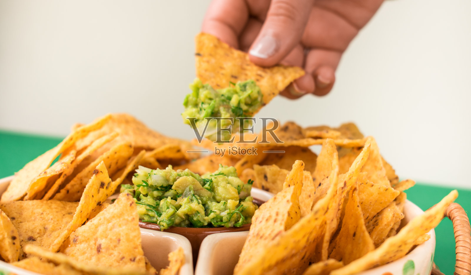 人们在锅里吃炸玉米片加鳄梨酱照片摄影图片