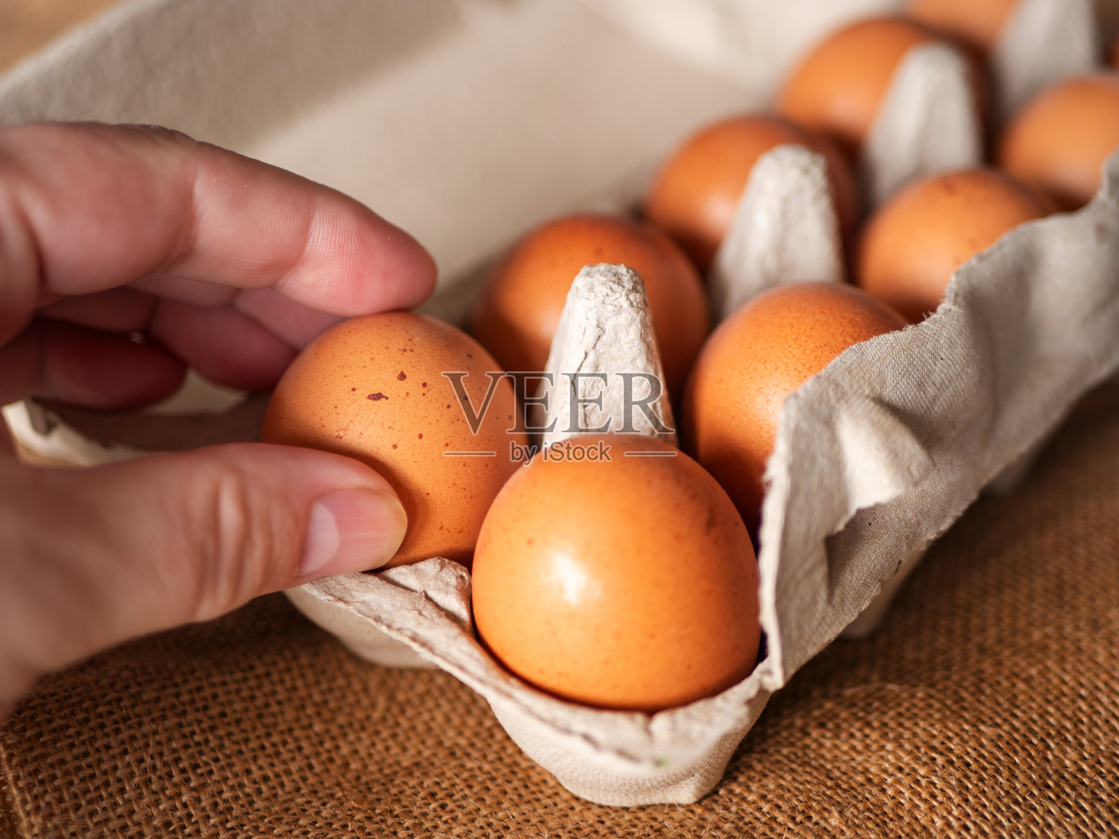 新鲜的棕色鸡蛋，装在粗布上的粗布纸盒里照片摄影图片