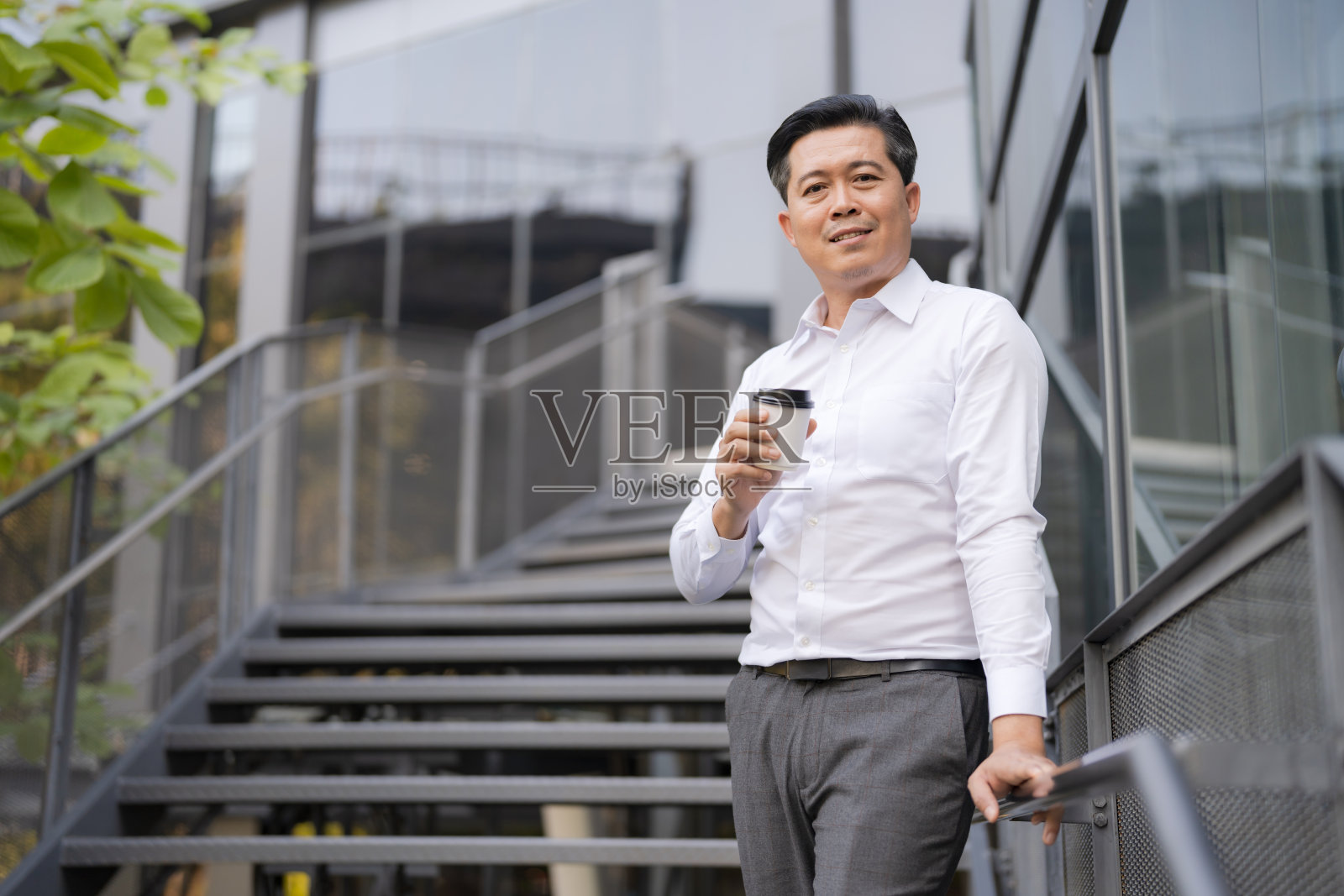 自信的商人走下室外楼梯照片摄影图片