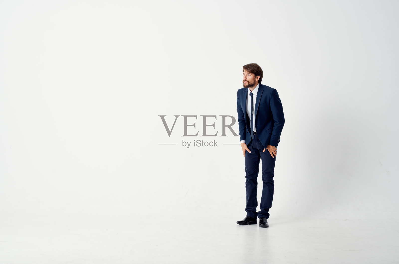 在浅色背景下，一个穿着经典西装的商人照片摄影图片