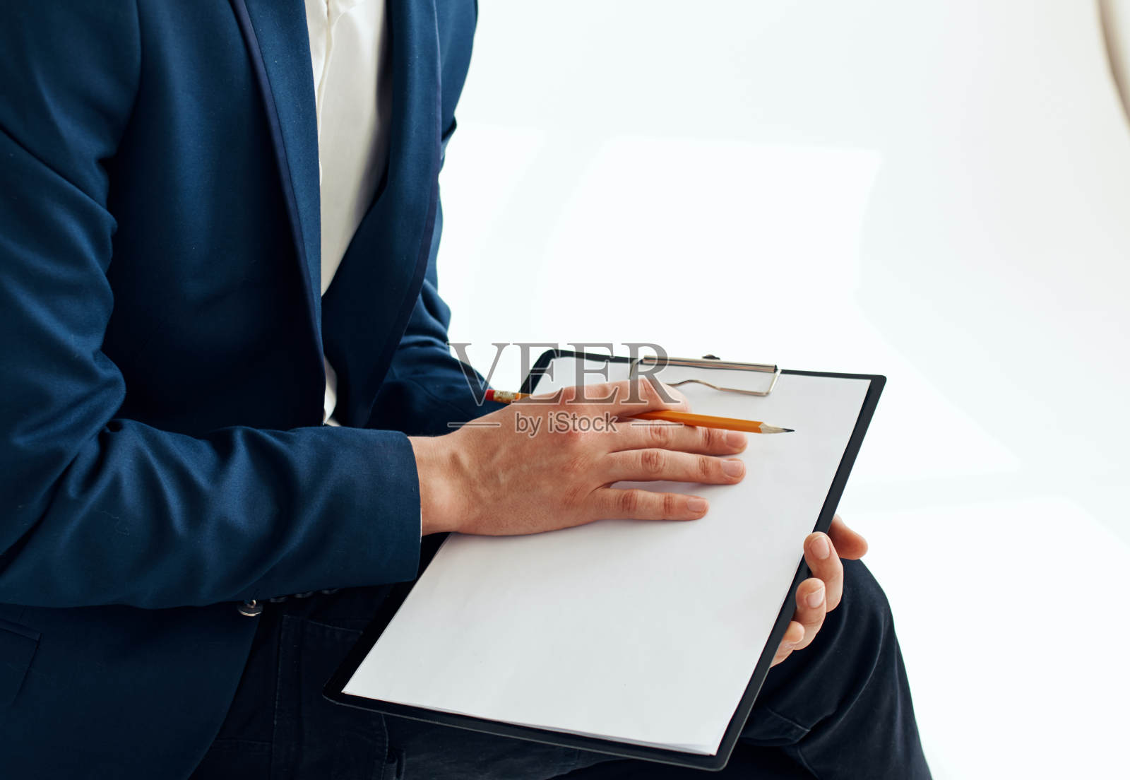 商人穿着西装，拿着文件，写下重要的信息照片摄影图片