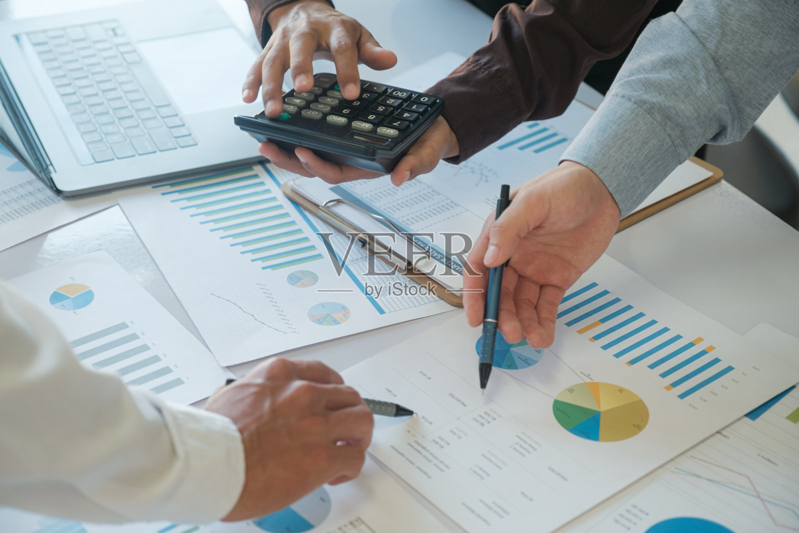 一组商业人士正在集思广益，分析投资项目的数据。照片摄影图片