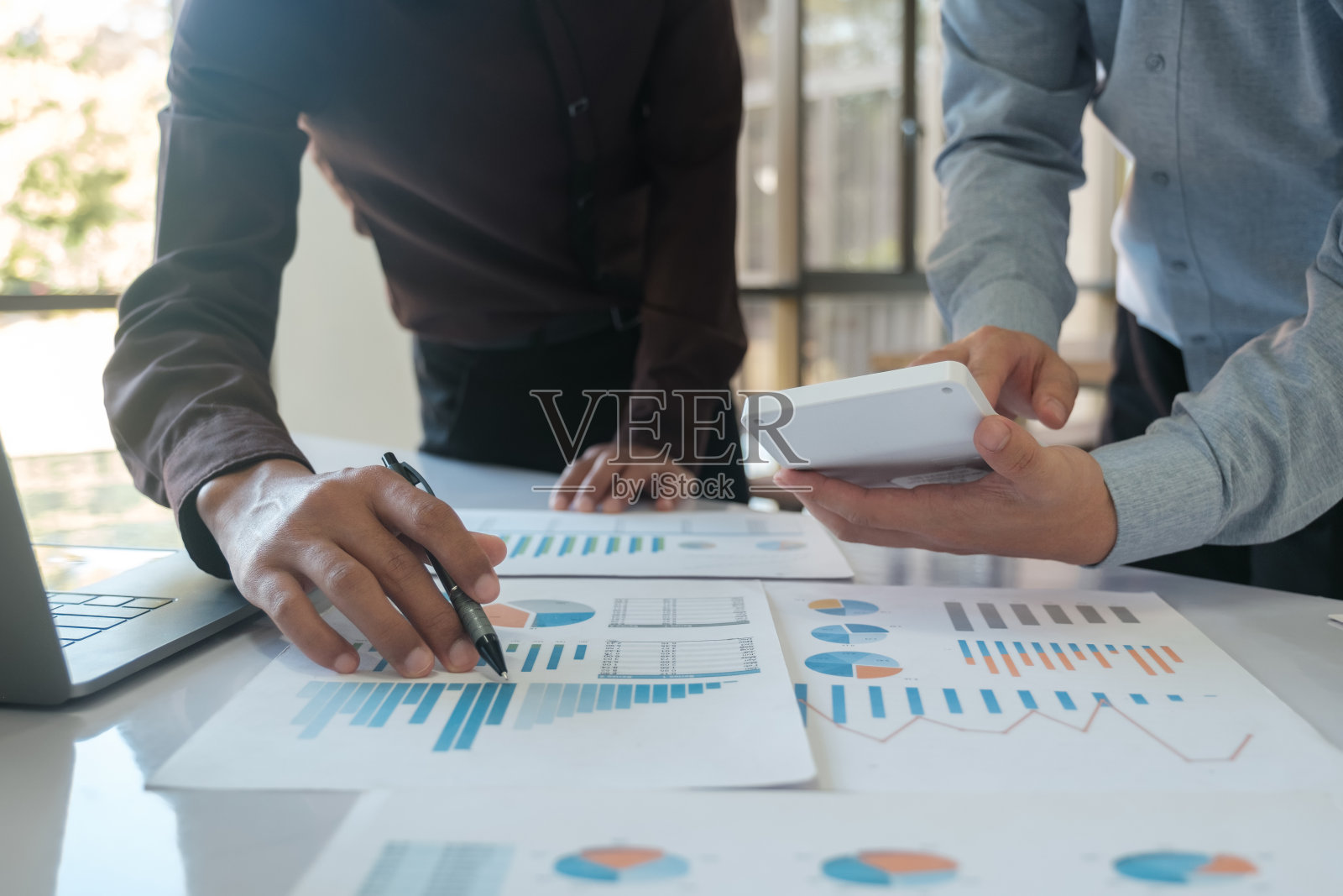 一组商业人士正在集思广益，分析投资项目的数据。照片摄影图片