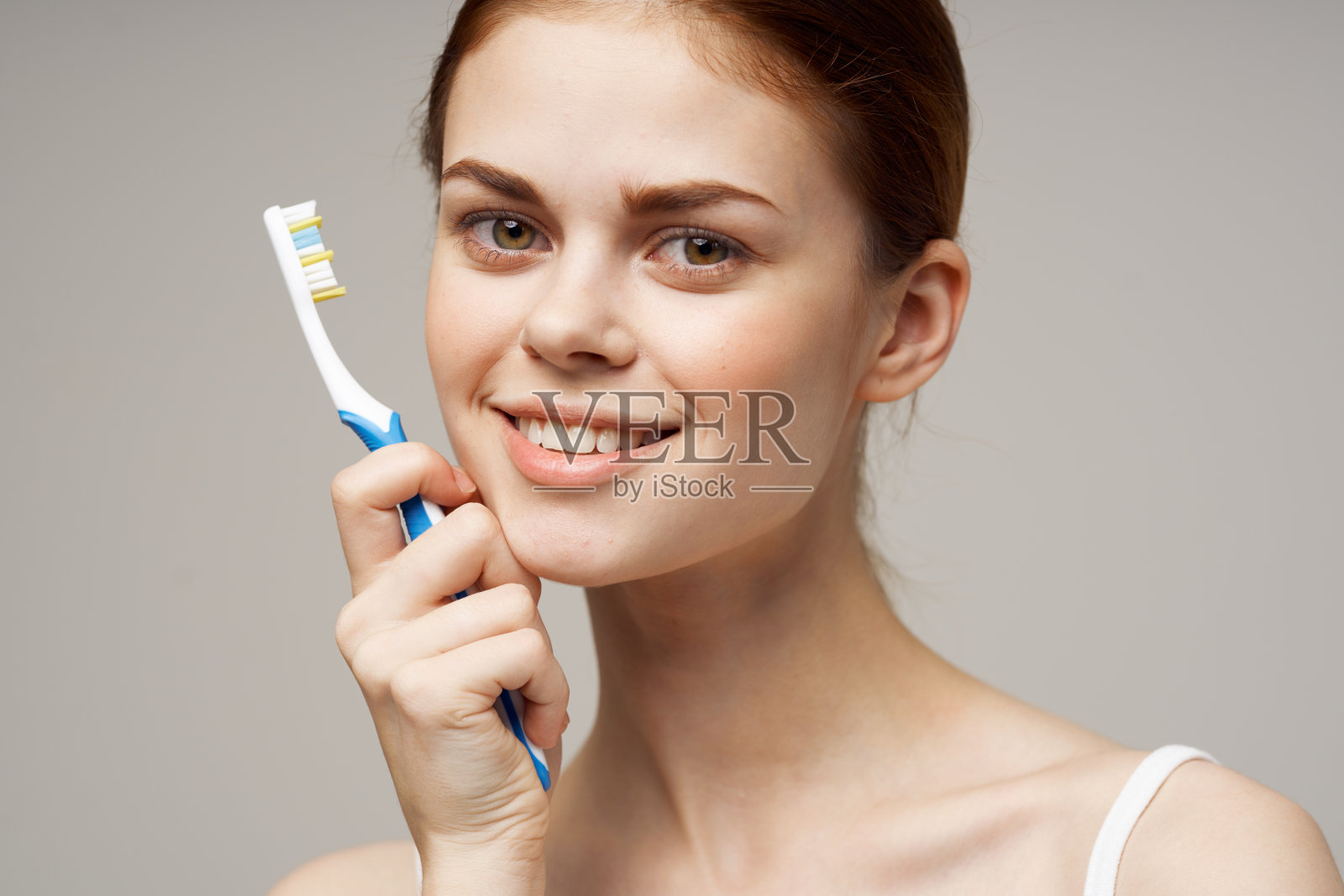 穿白t恤的女人牙刷微笑健康卫生照片摄影图片