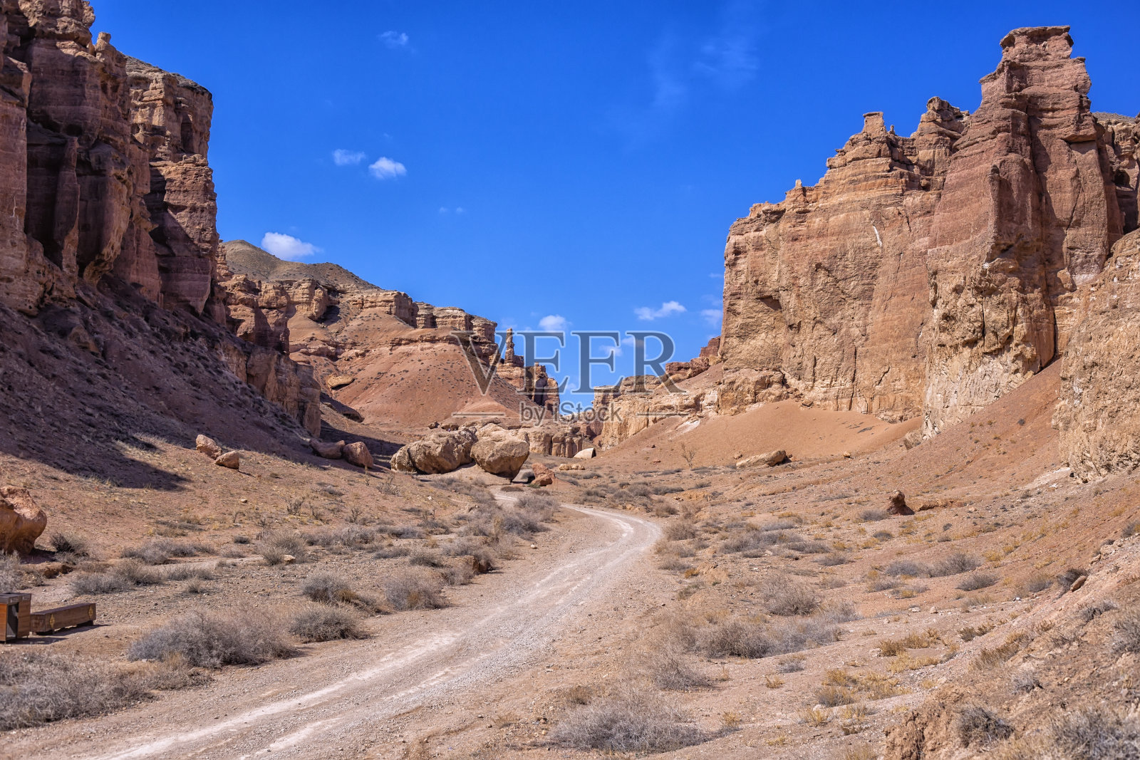 哈萨克斯坦沙漠中巨大的查林峡谷。左右两边都是高大美丽的建筑，中间是一条蜿蜒的草原道路。野性的自然和狂野的西部。照片摄影图片
