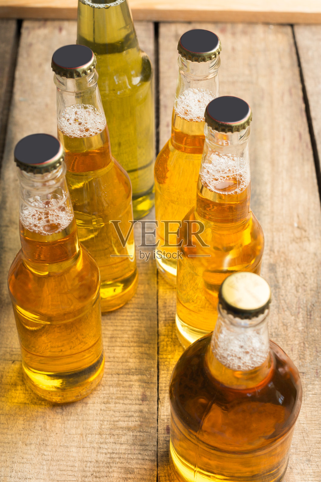 木桌上放着啤酒瓶。照片摄影图片