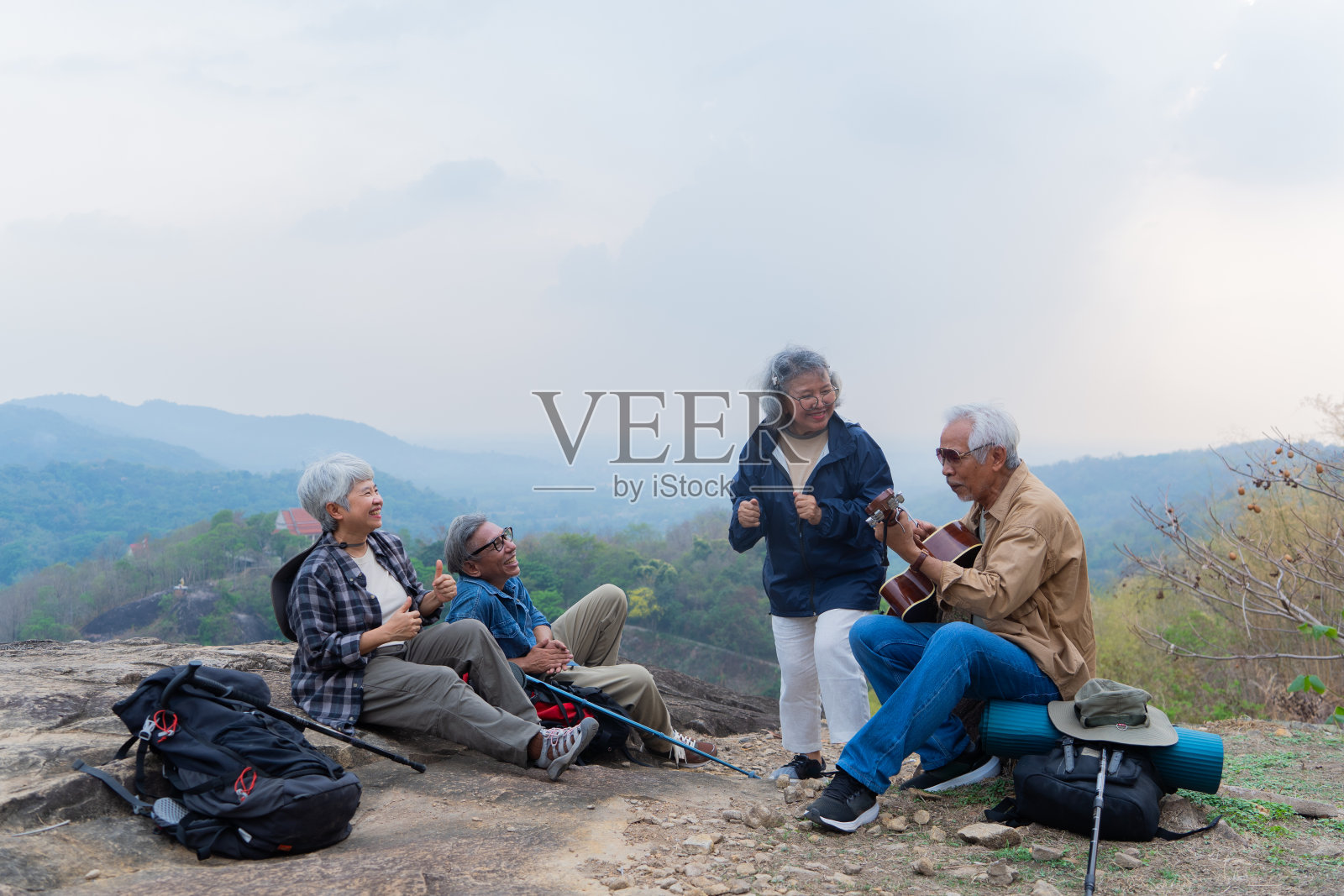 亚洲老年人喜欢在山上弹吉他照片摄影图片