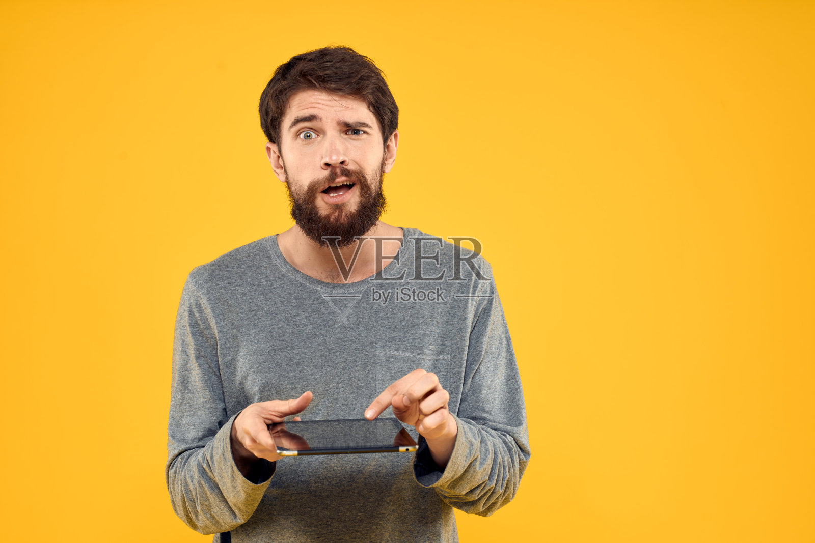 情感男人手持平板电脑科技互联网设备生活方式黄色背景照片摄影图片