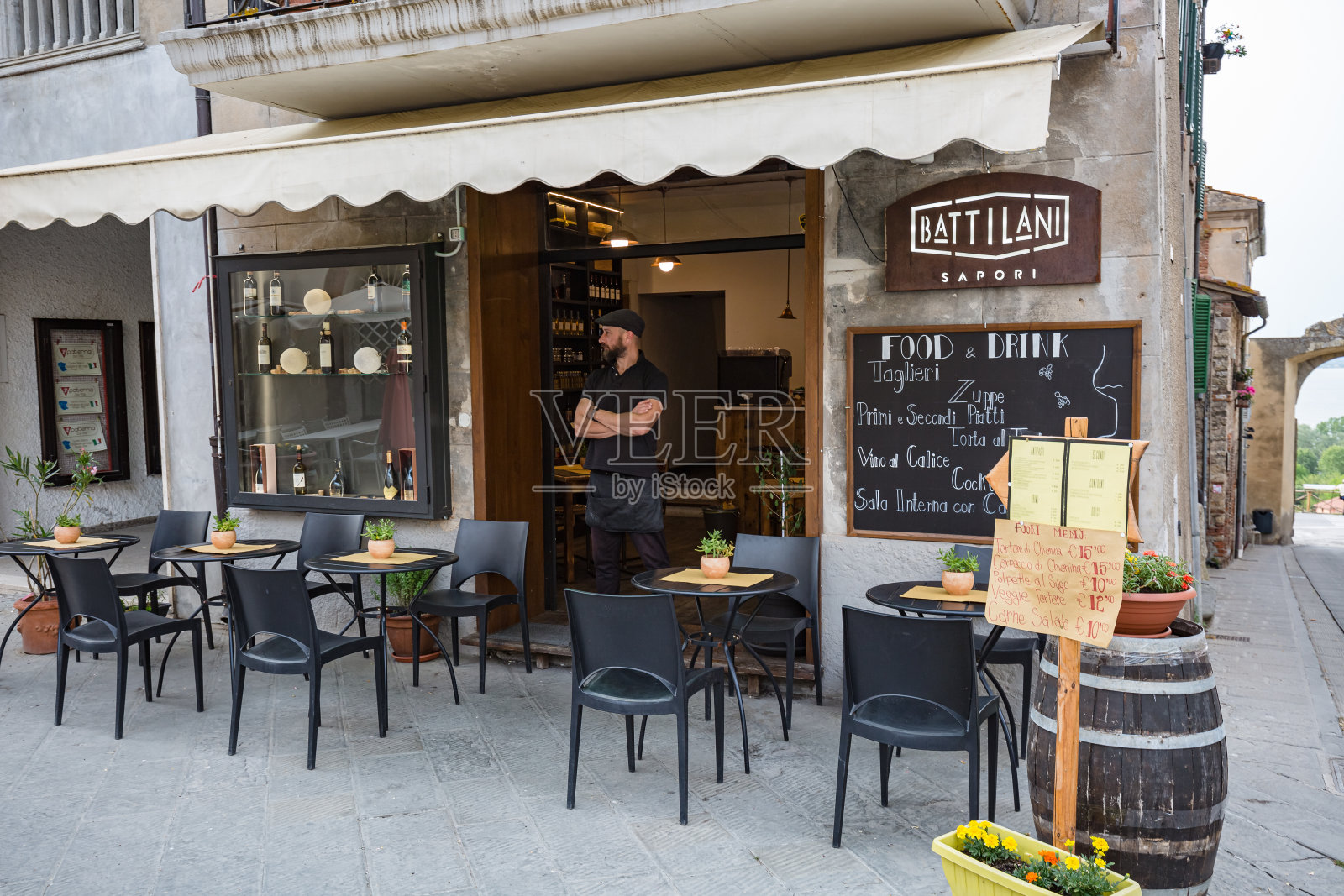 意大利，卡斯蒂廖内德拉戈:城市景观。走在历史悠久的狭窄街道上。人行道上咖啡照片摄影图片