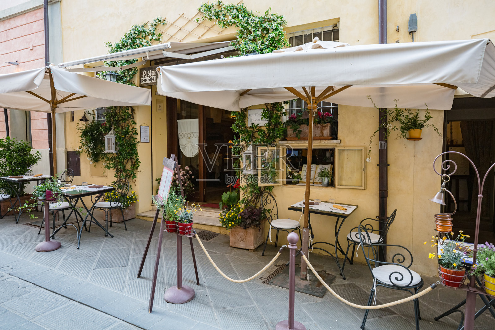 意大利，卡斯蒂廖内德拉戈:城市景观。小型开放式餐厅的景观。行走的历史狭窄街道照片摄影图片