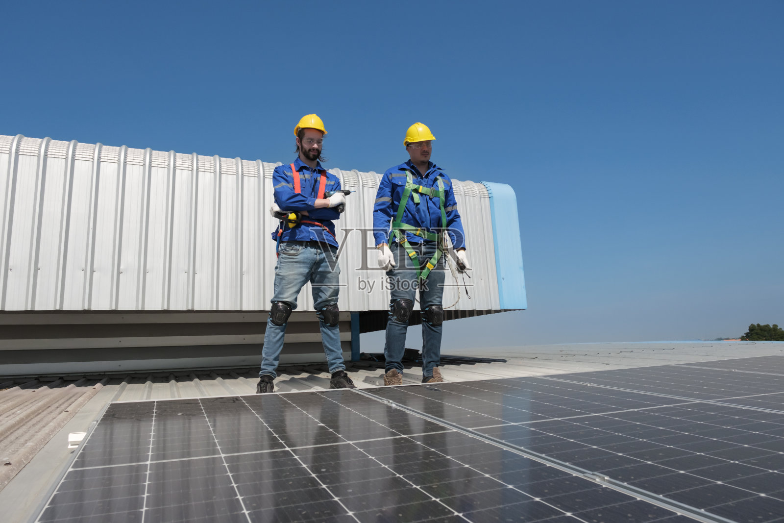 工程师在工厂的屋顶上安装太阳能电池照片摄影图片