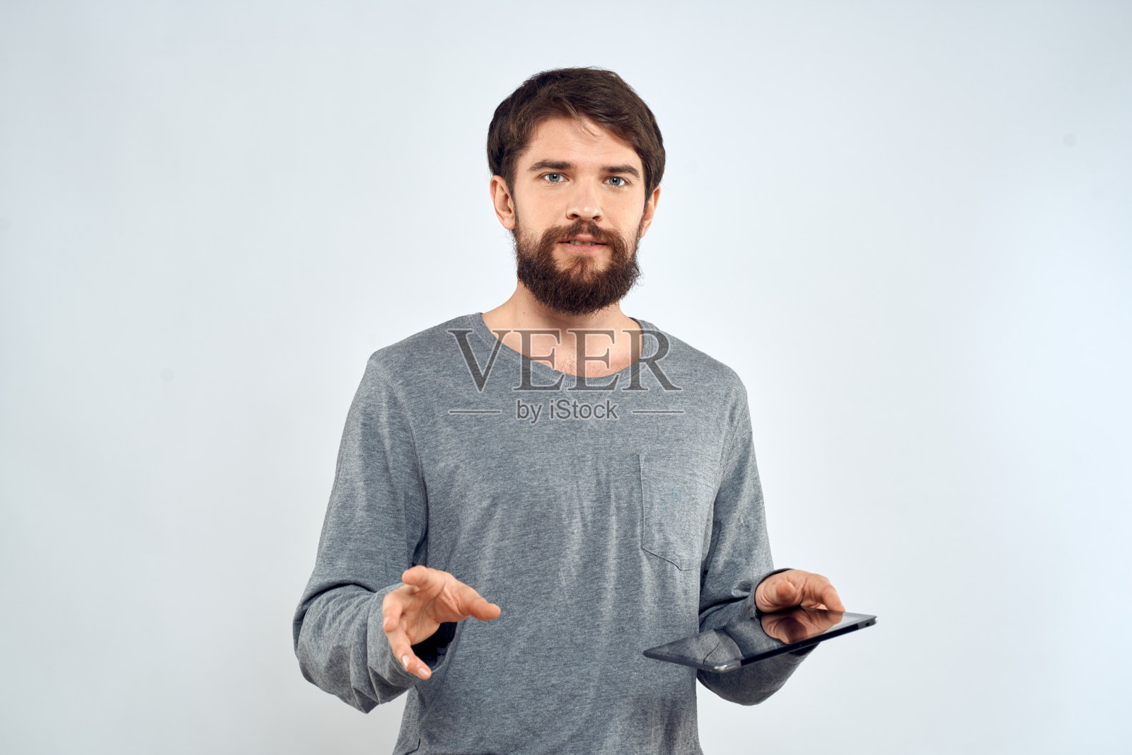 一个穿着灰色毛衣的男人手里拿着平板电脑，情感互联网科技生活方式的光背景照片摄影图片