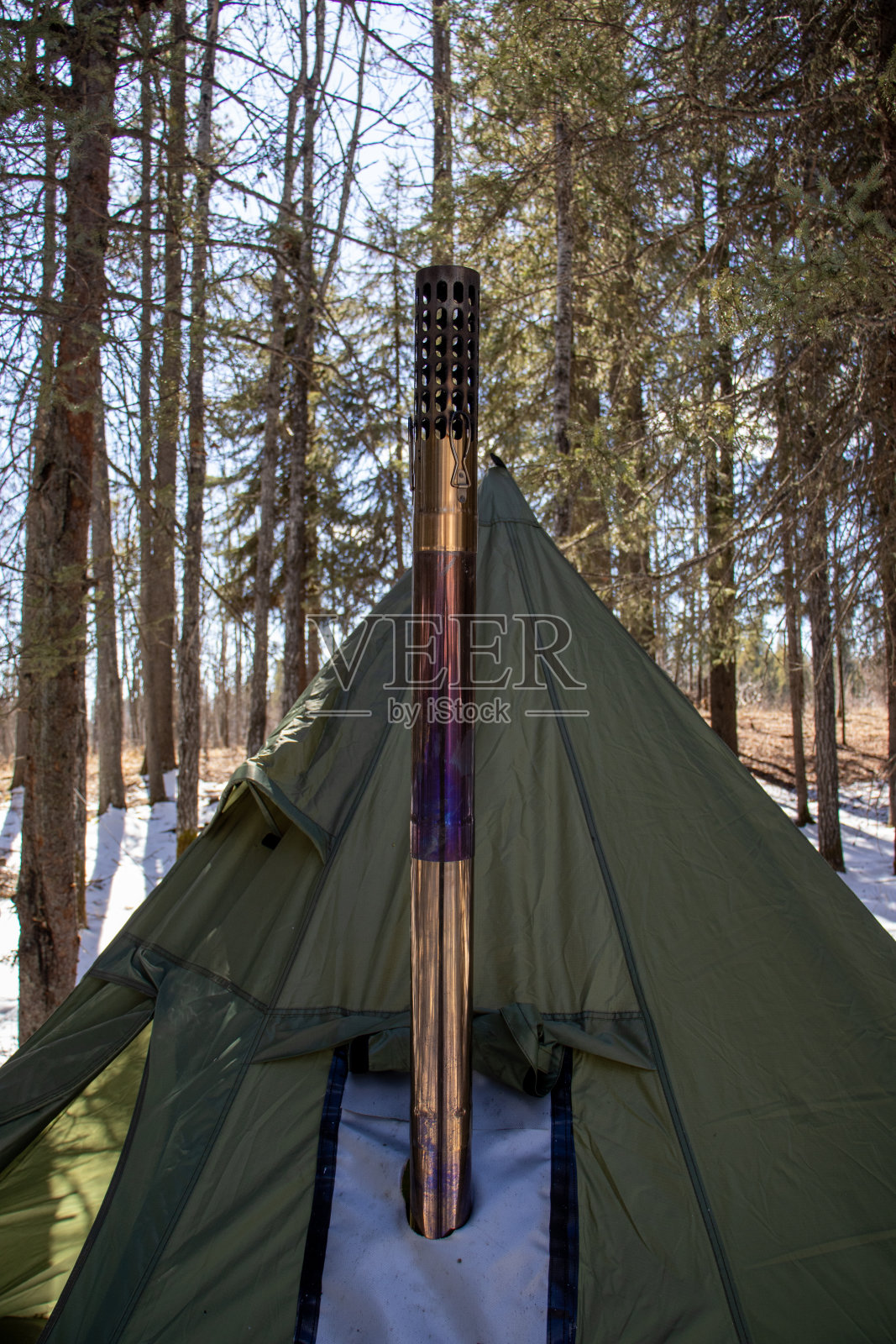 冬令营:雪中带金属烟囱的圆锥形帐篷照片摄影图片