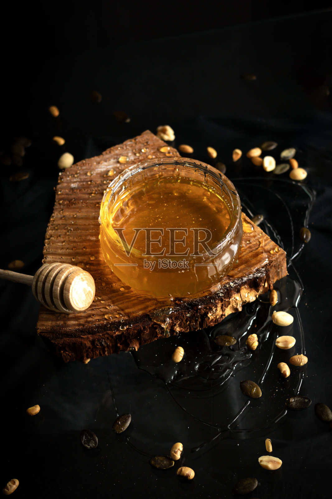 黑底玻璃罐里的新鲜蜂蜜。美味地照片摄影图片